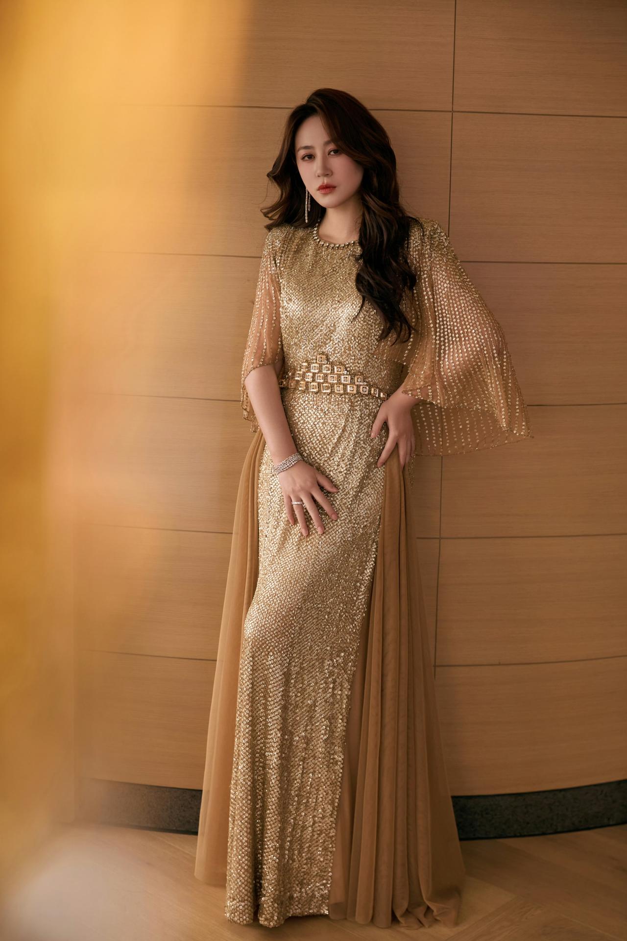 马丽，她身着Jenny Packham金色亮片礼服，搭配斗篷袖、亮钻收腰腰带，还