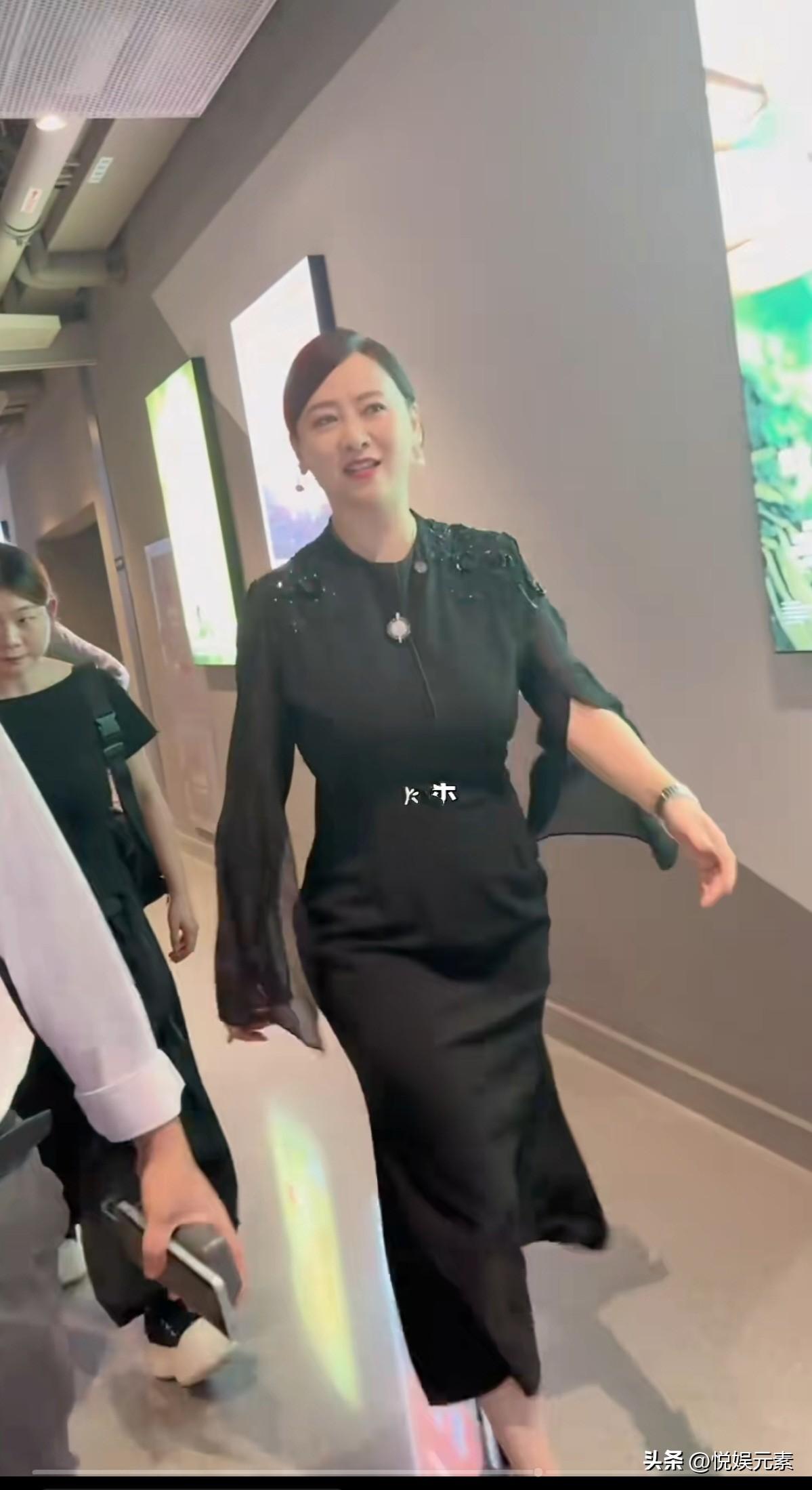翁虹一身黑色连衣裙，贴身裹住丰润的身形，头发挽得一丝不苟，步子不疾不徐，通身透着