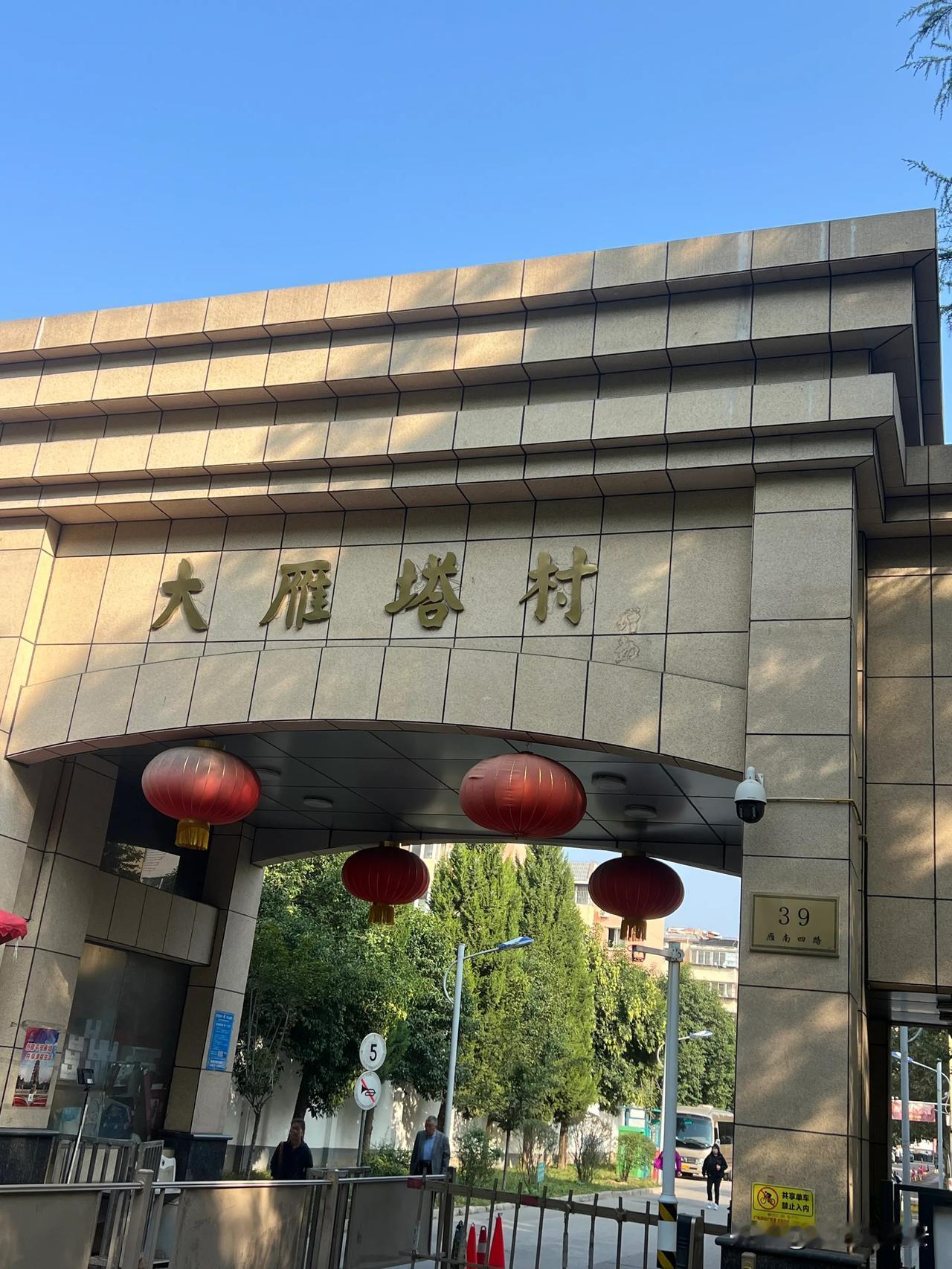 今天上午路过雁南四路，不经意间发现

大雁塔村的小区门楼前的题名者落款被擦掉了，