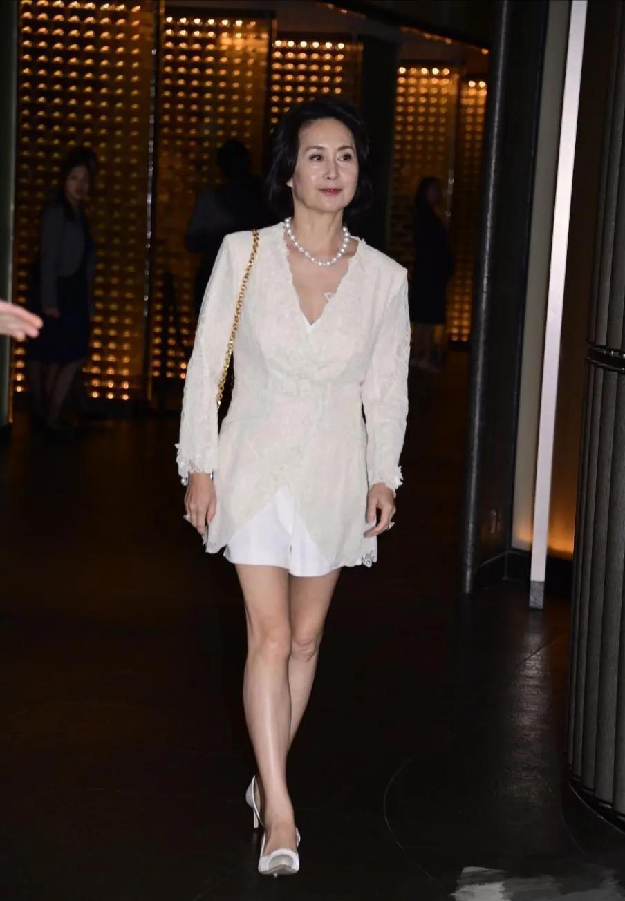 何超琼盛装出席张艾嘉儿子婚礼，61岁的她依旧光彩照人，身穿米色的套装，妆容精致，