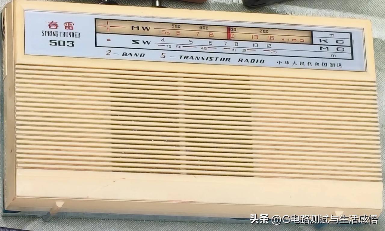 经典春蕾503晶体管二波段收音机，奶白的机身刻满时光印记。中波短波来回拨动旋钮，
