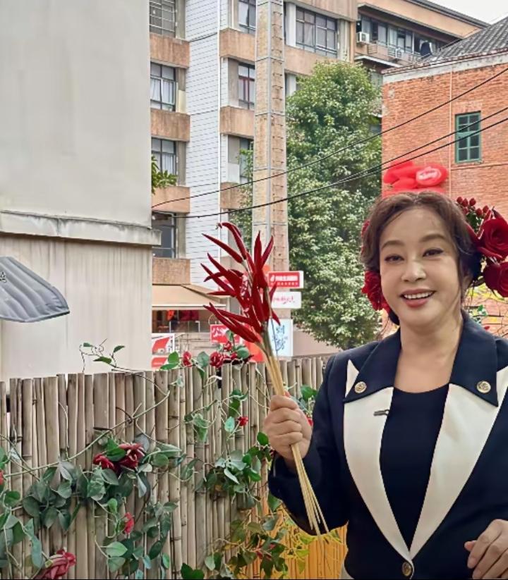 3月8日，刘晓庆现身重庆，她一身干练黑色西装，头上别着一朵鲜艳的大红花，造型亮眼