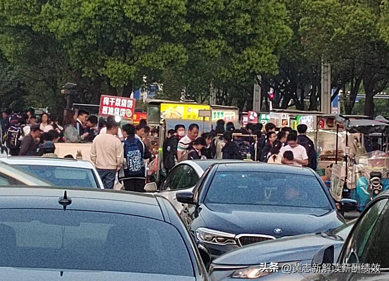每次下午来学校接我的孩子，总是会经过这十几个学校门口的摊位，造成了拥堵，通过时间