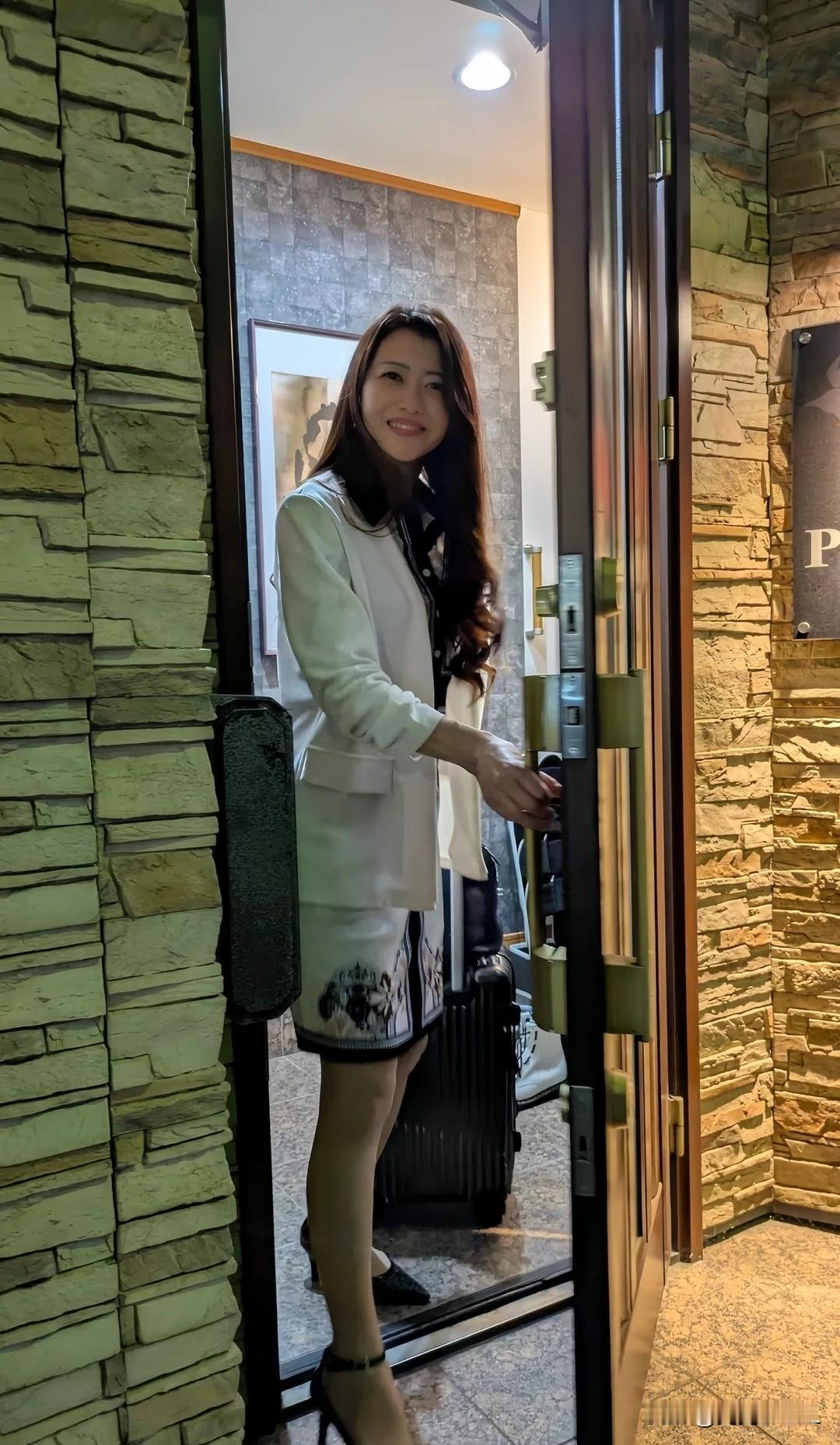 这位女士正准备出门，带着行李箱。明星到家了。