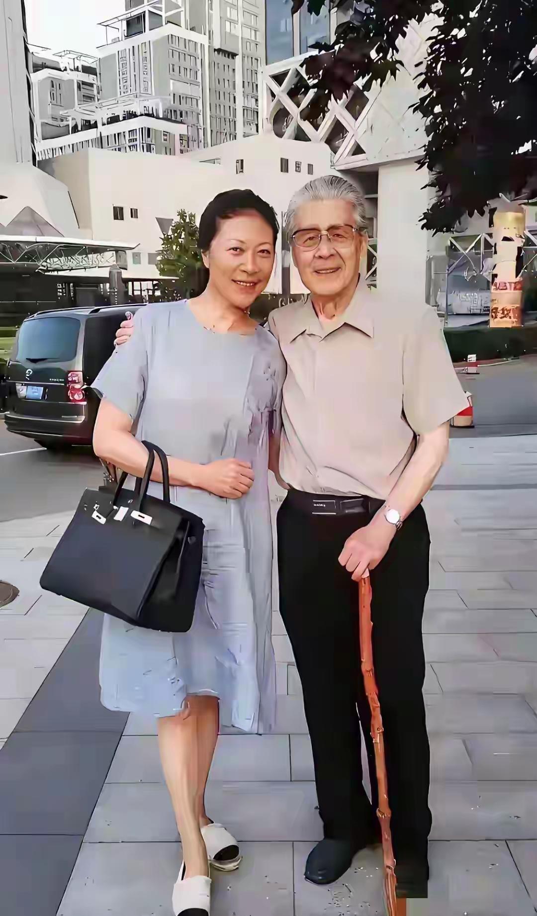 两位老人手挽手散步在城市街道上。看到老爷子就让我想到了渴望，小时候天天坐在电视机