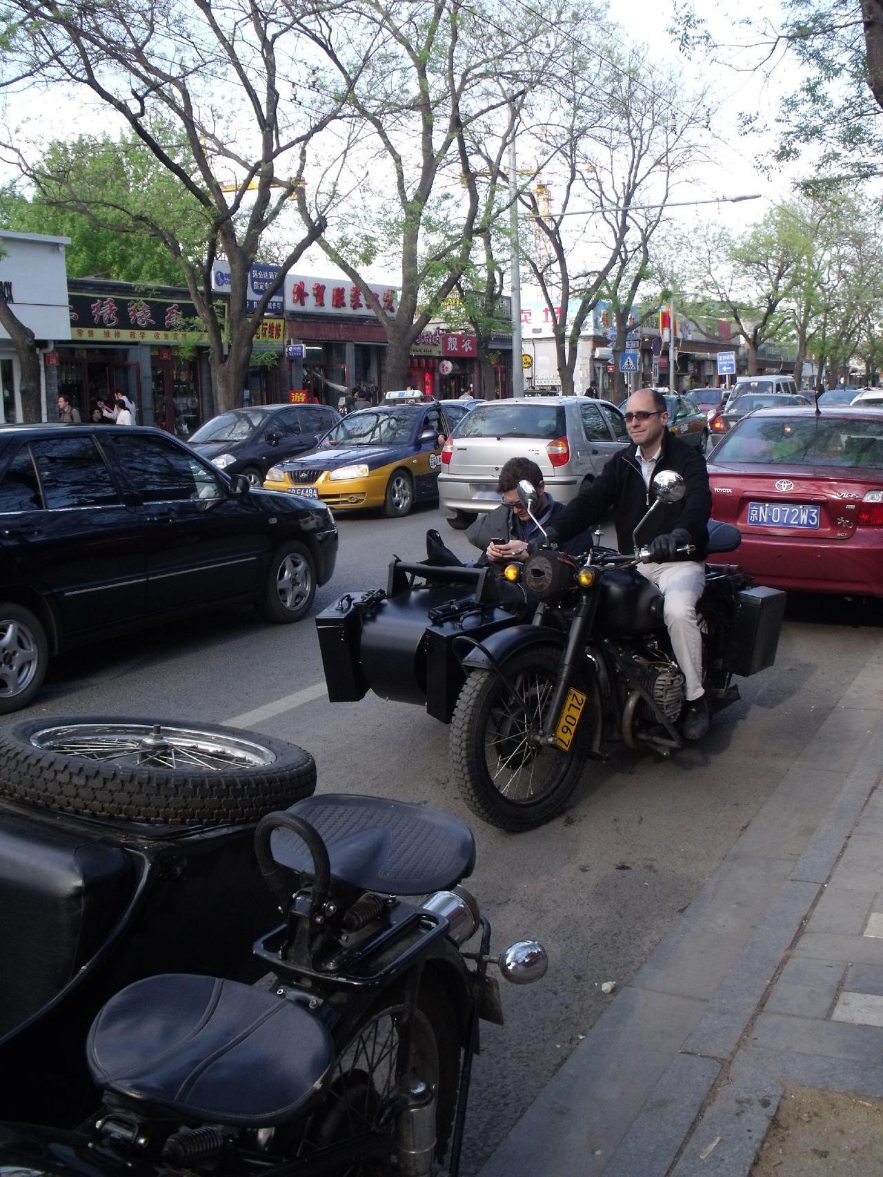🛵复古边三轮停在街角，像时光遗落的勋章✨。树影斑驳里，老北京的烟火与骑士的自由