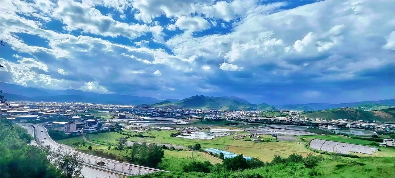 山间小镇的美景，云卷云舒，小桥流水潺潺，麦田在微风中泛起波浪，好个风景！