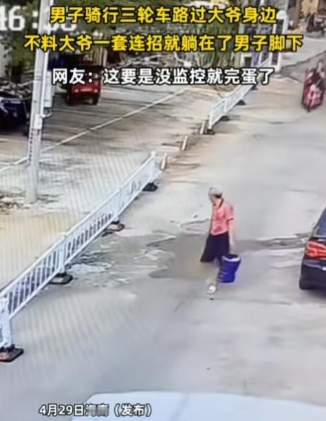 海南，男子骑行三轮车路过大爷身边，不料大爷一套连招就躺在了男子脚下。这算碰瓷吧，