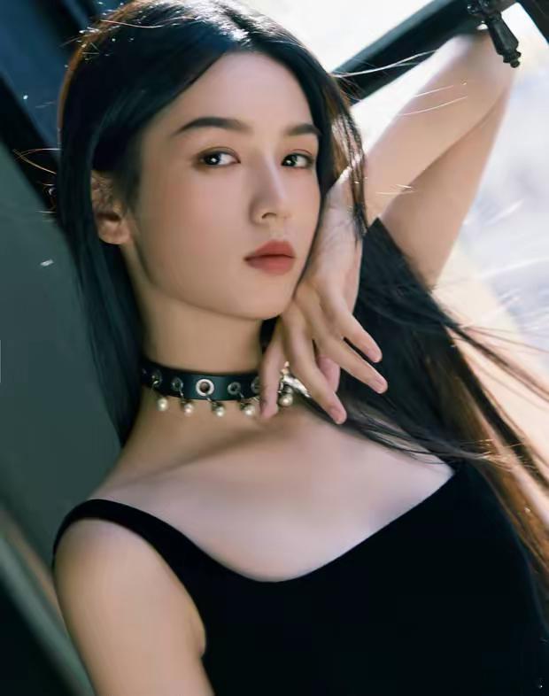 周也身穿黑色吊带长裙的美图释出，她脖子戴着皮质项圈，一手掐腰仰头，酷飒又不失性感