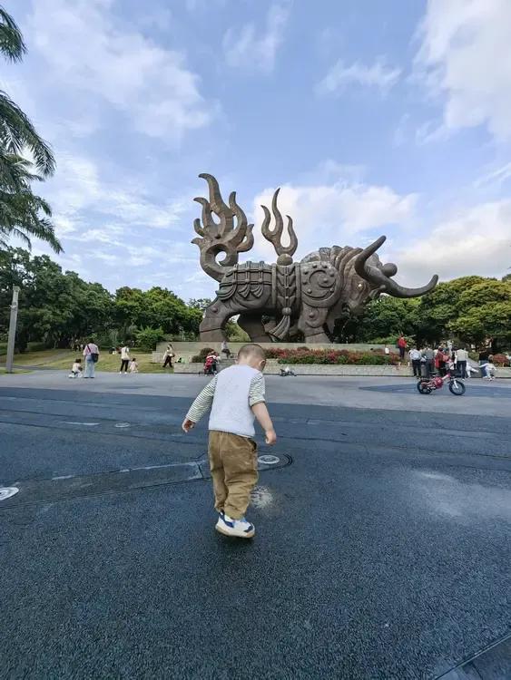 越越在四海公园“拓荒牛”前面踩水。
那片空地上，中午会有喷泉表演。我们抵达的时候