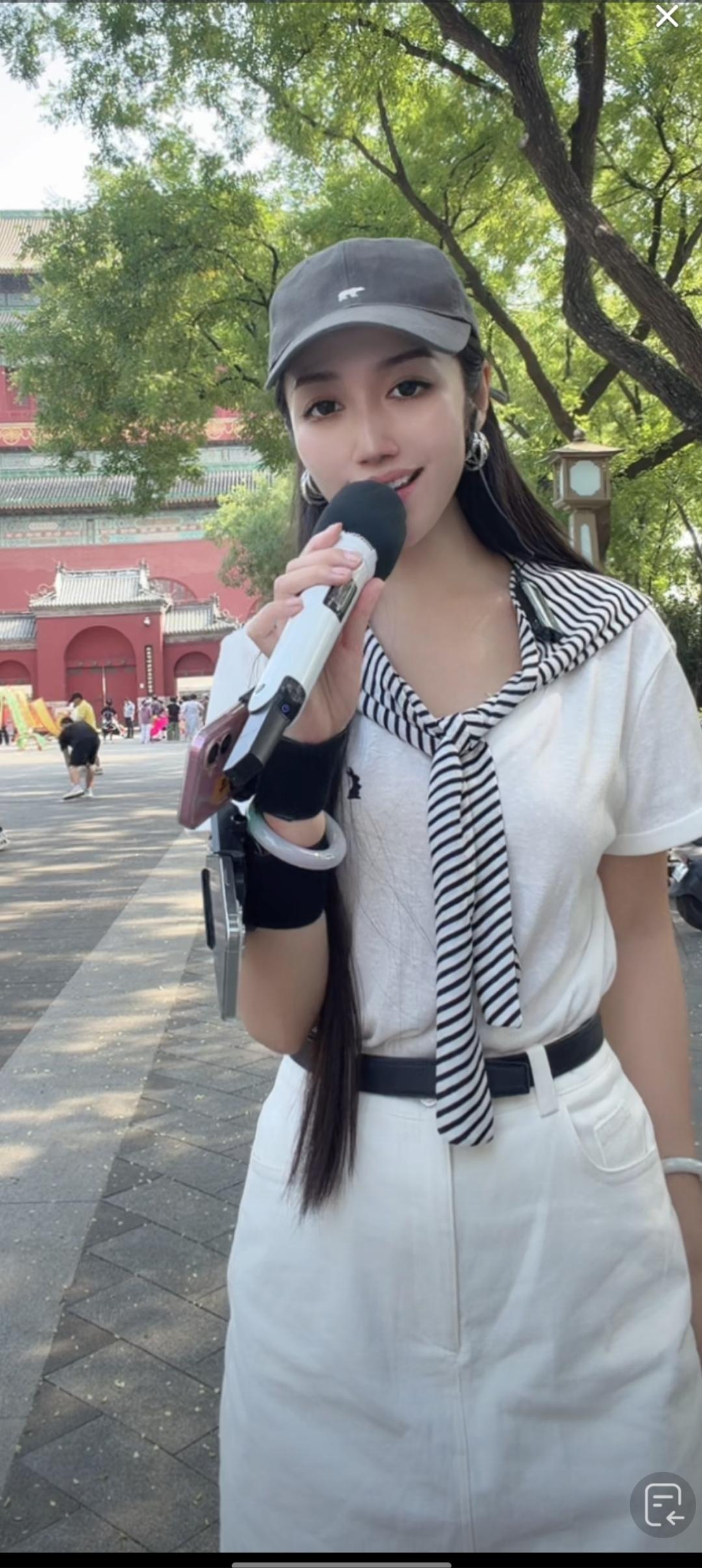 这姑娘在户外用麦克风说话。
