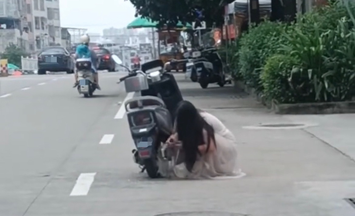 【玉林北流女子骑电车长裙被卷进轮毂里】7月31日，玉林市北流一名女子穿长裙骑电动