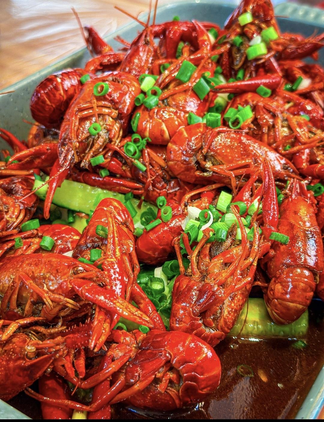 夏夜的风刚掠过江岸，巷口那口滚着红油的大铁锅便“咕嘟”唱起歌。我提一袋活蹦乱跳的