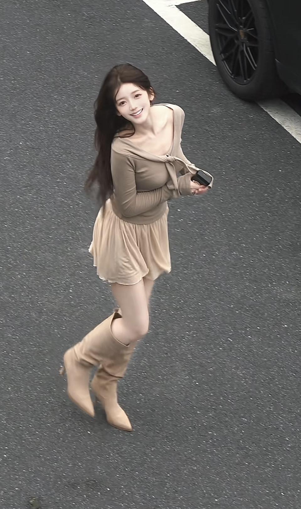 一个女孩在马路上开心地跑着。
