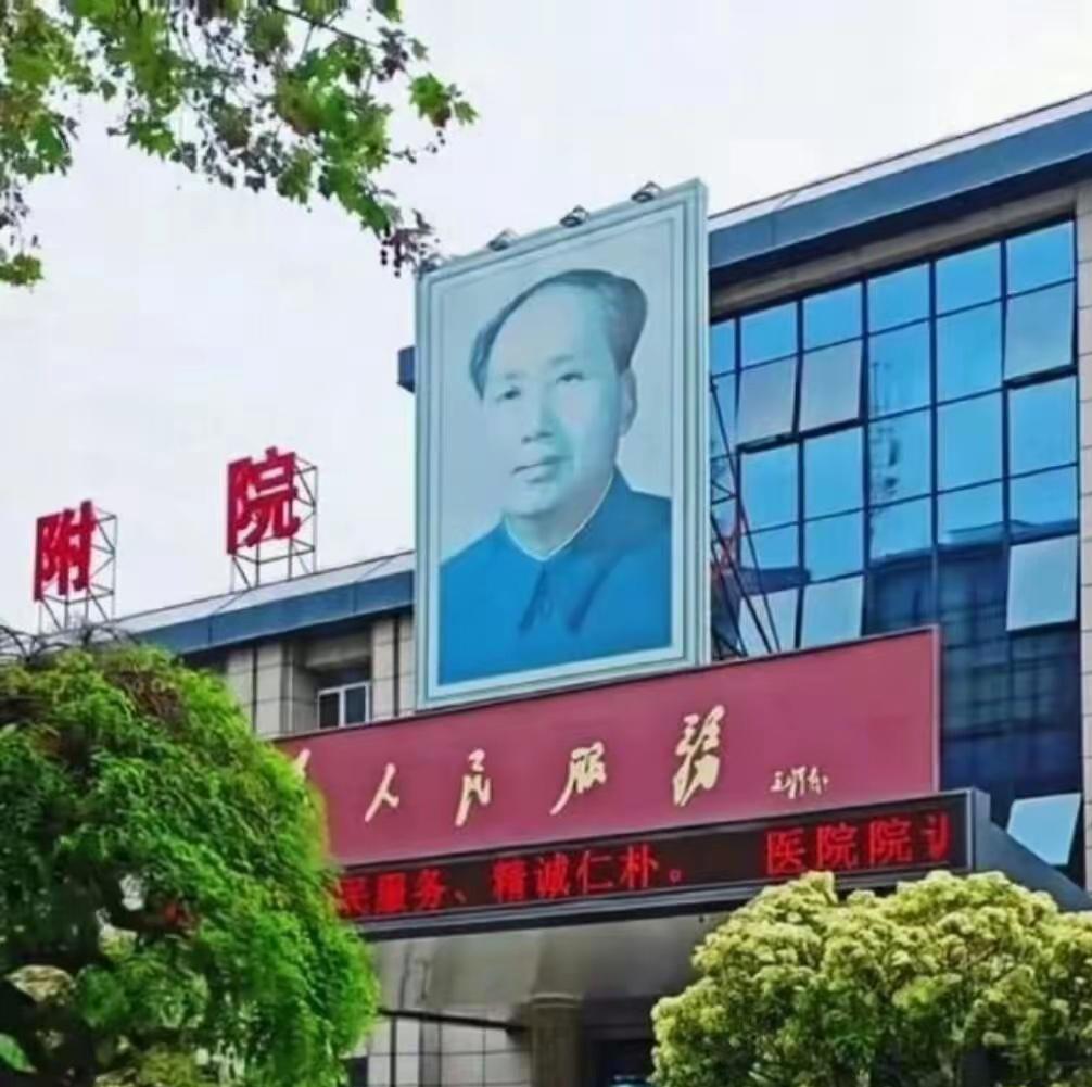 像这样坚守初心的医院实在少见。门诊门口端正悬挂着毛主席画像，“全心全意为人民服务