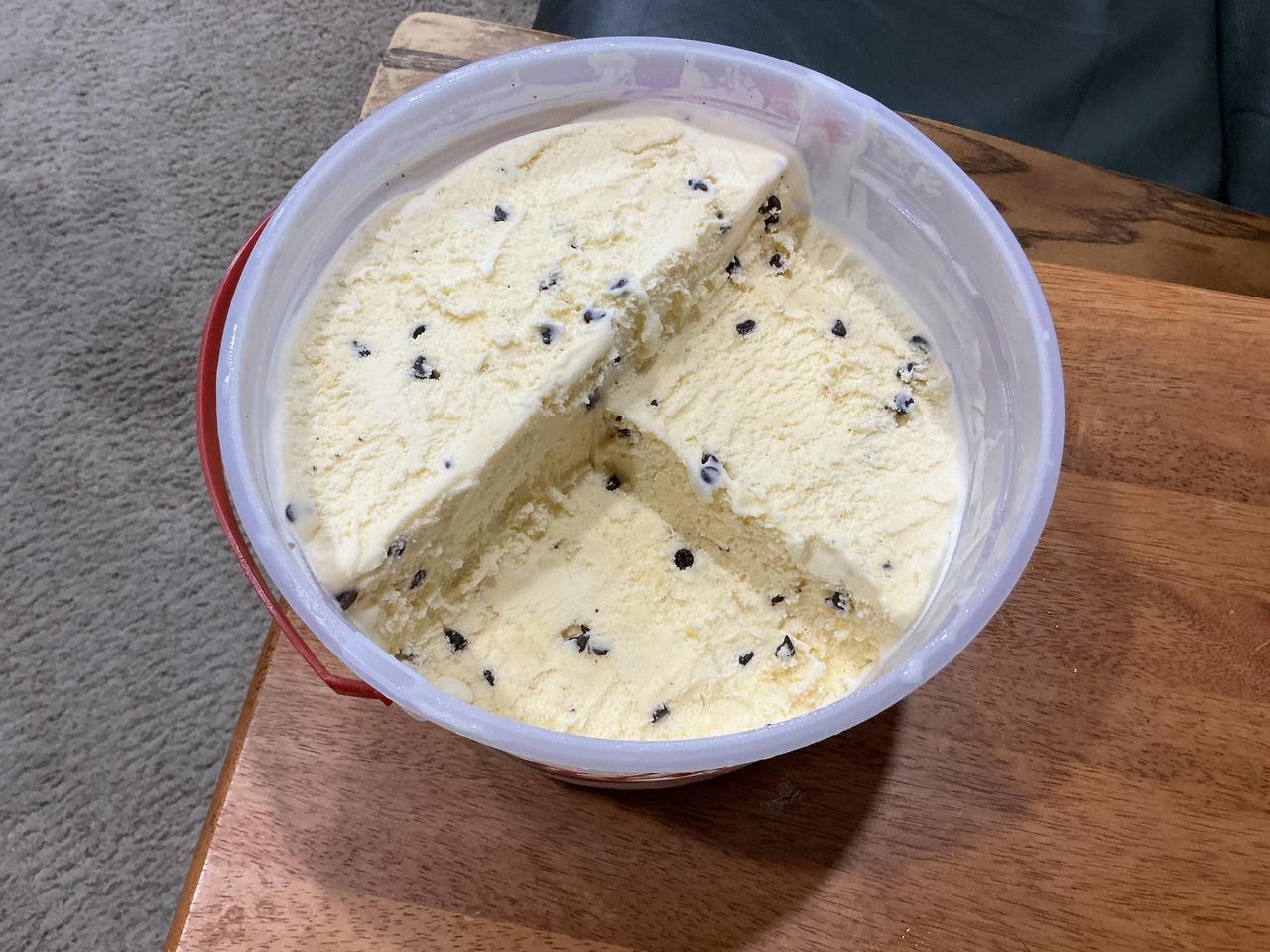 一个男孩吃家庭装冰淇淋，硬是把圆桶吃成了露天采石场，一级一级台阶整整齐齐，边坡修