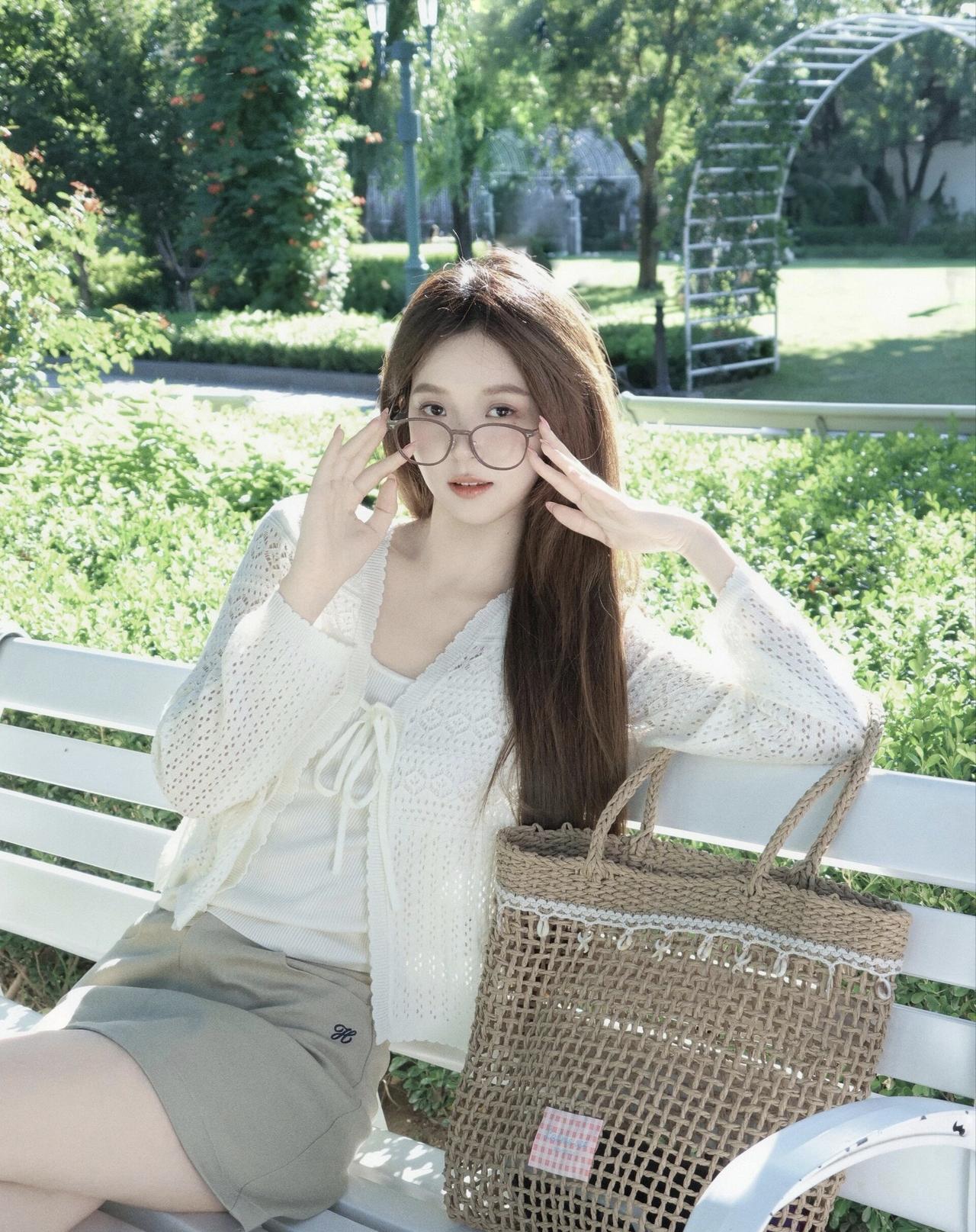 阳光明媚的午后，少女在公园长椅上享受美好时光。