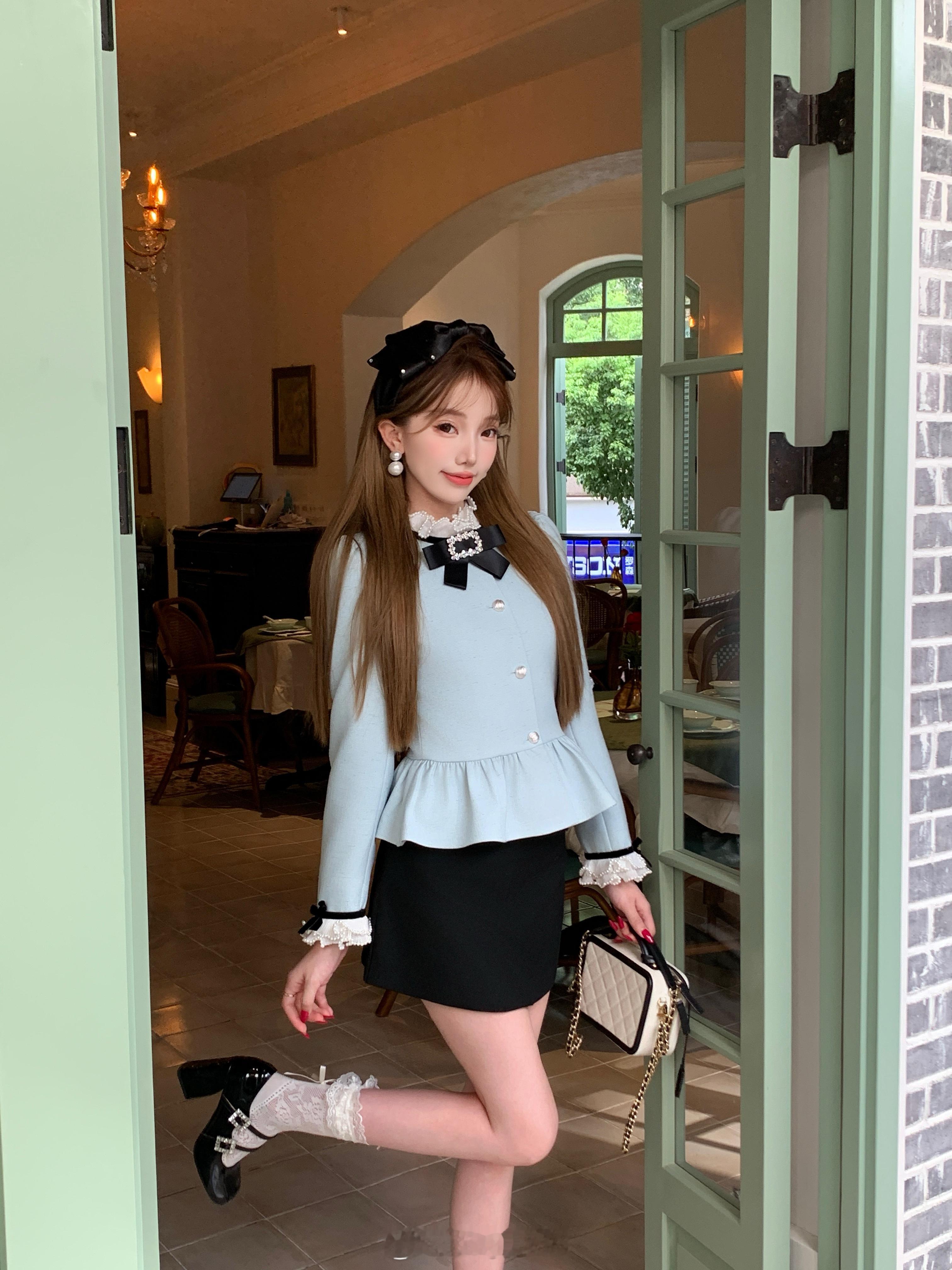 浅蓝上衣搭配黑色裙甜美与内敛的丸美融合衣蝴蝶结与贝壳纽扣精致吸睛荷叶边下摆灵动俏
