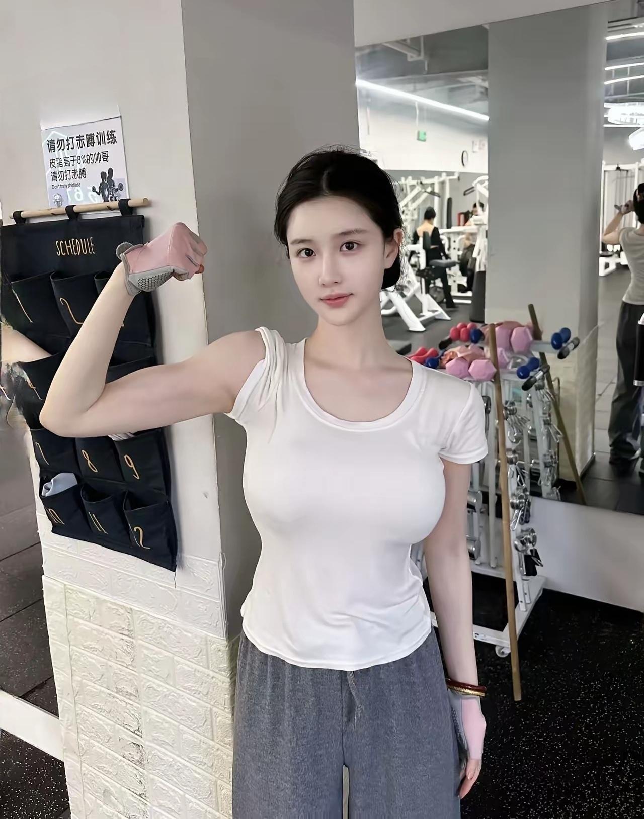 健身房里，女孩展示肱二头肌。
