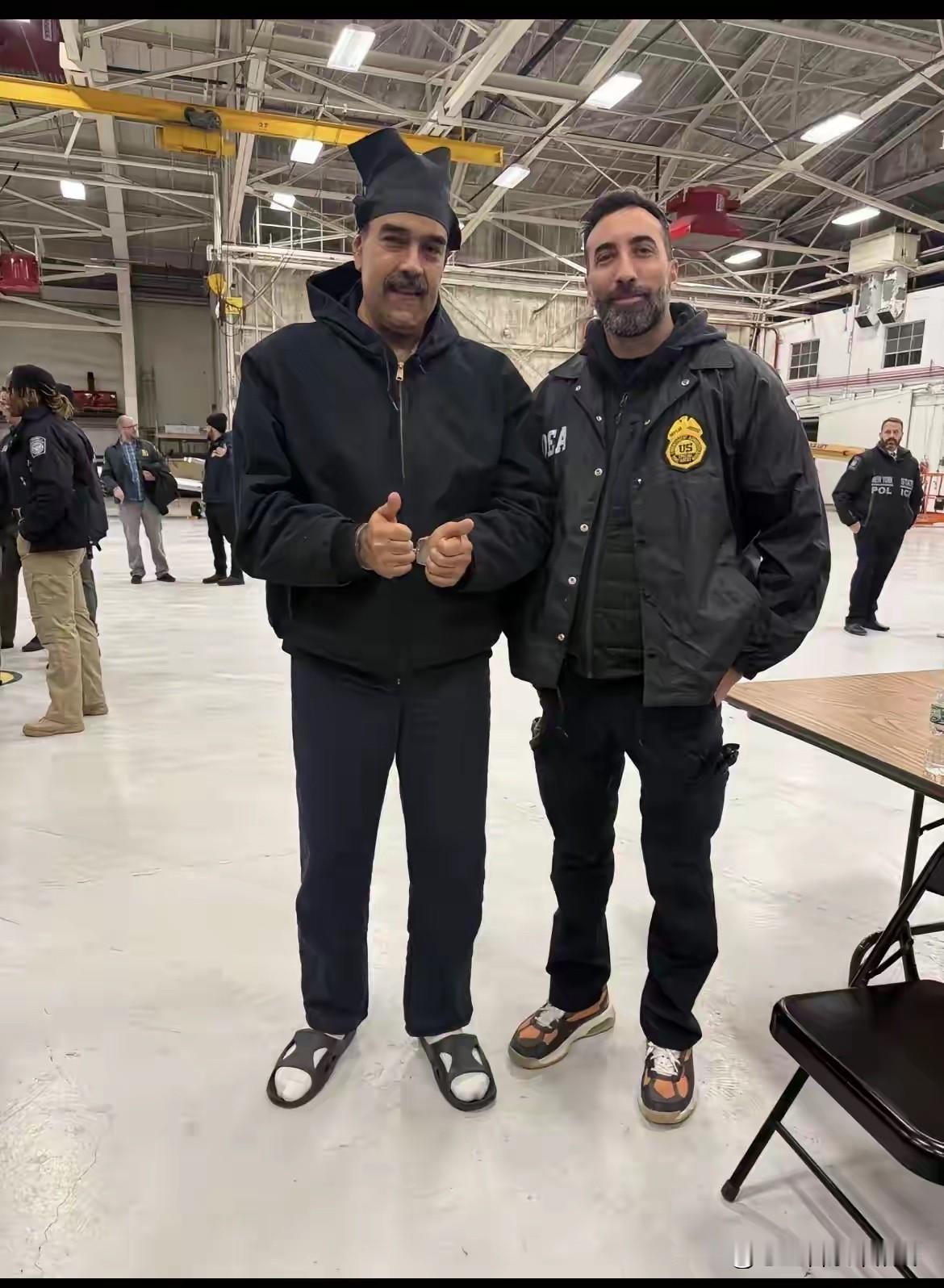 真是佩服马杜罗这心态啊！脚上穿着双拖鞋，手上还戴着手铐，头上戴的帽子看起来像小丑