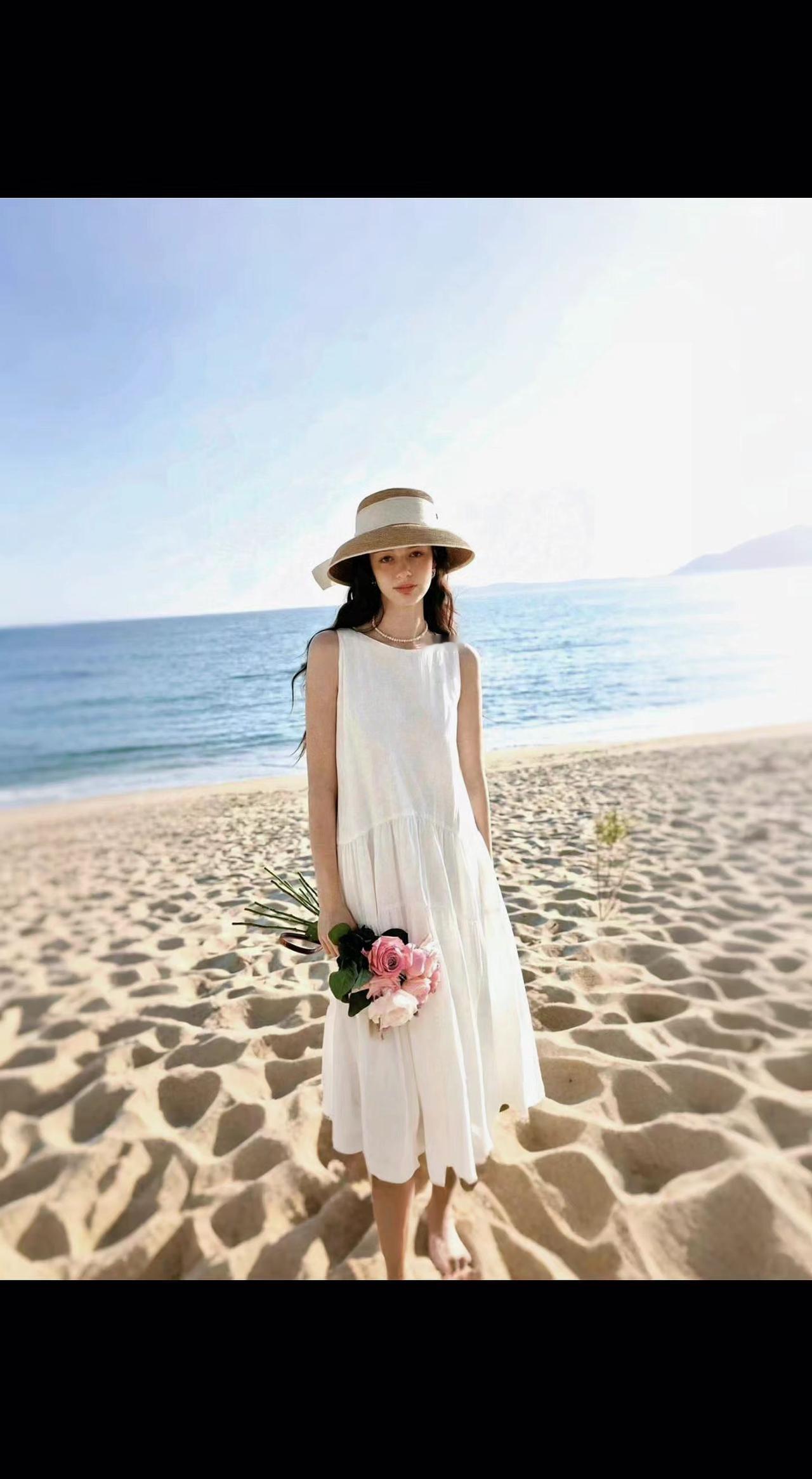 🌊白裙踩碎金沙浪，草帽盛满海风光。花束藏着夏日诗，此刻时间也慢烫。