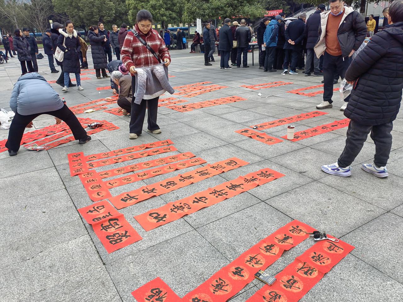 为了增添过年的氛围，弘扬传统文化，书法爱好者献爱心，免费为人们书写对联。
   