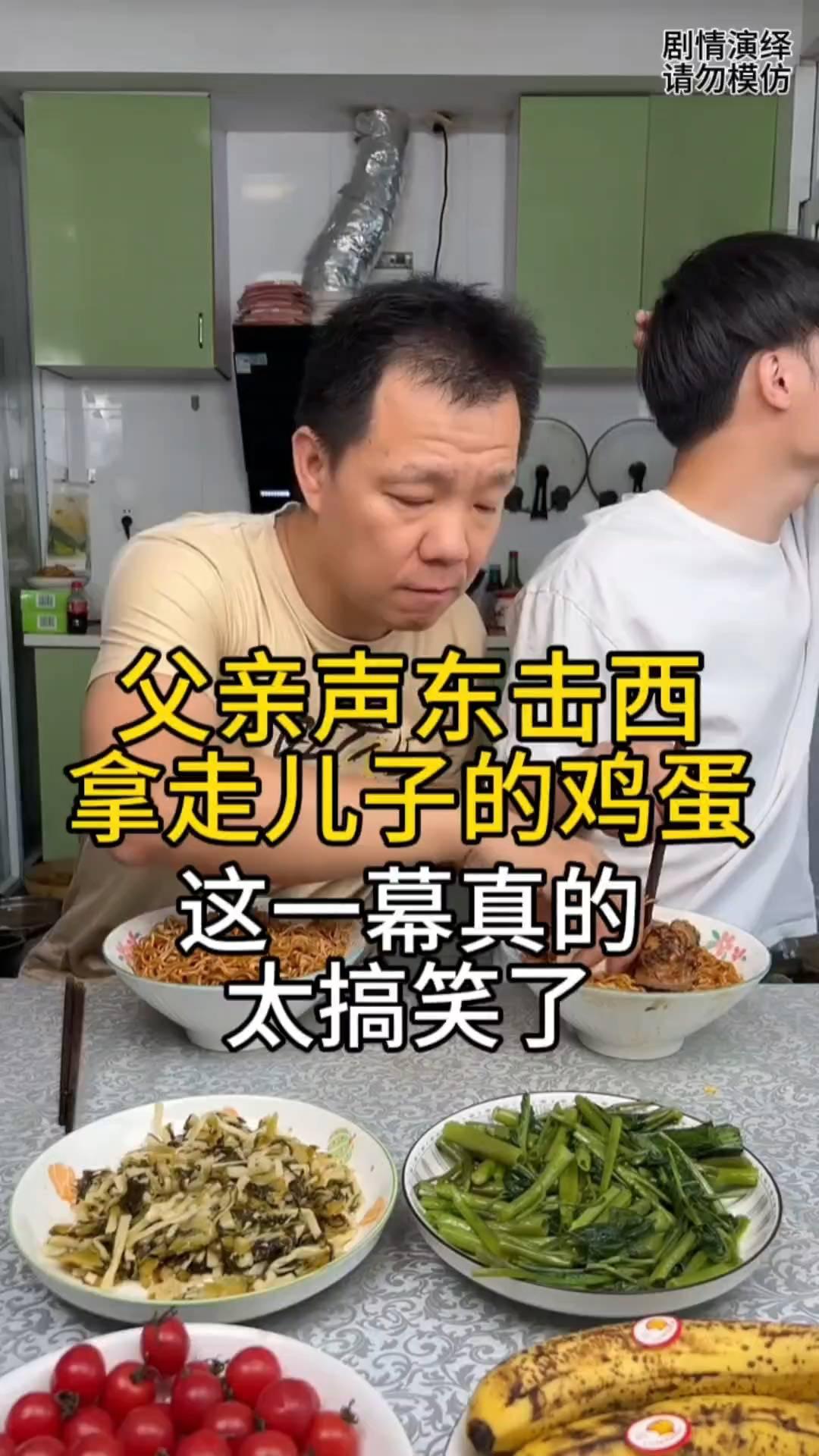 父亲声东击西拿走儿子的鸡蛋。
父子两个正在吃面条，这时爸爸声东击西拍了一下儿子。