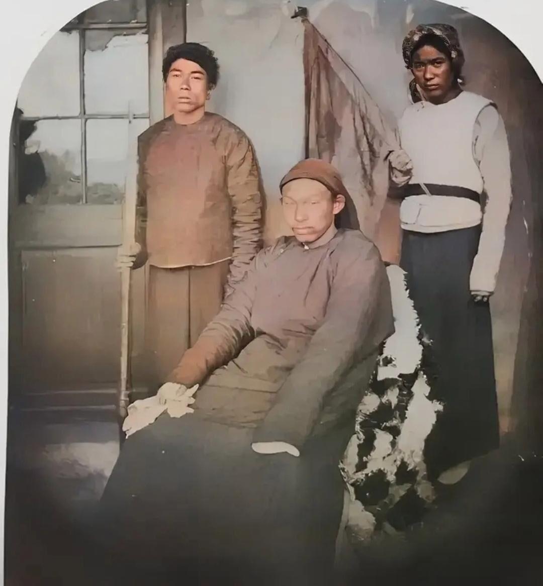 这是太平军中的“戴王”黄呈忠，与他的两个亲信随从的一张老照片。

端坐在椅子上的