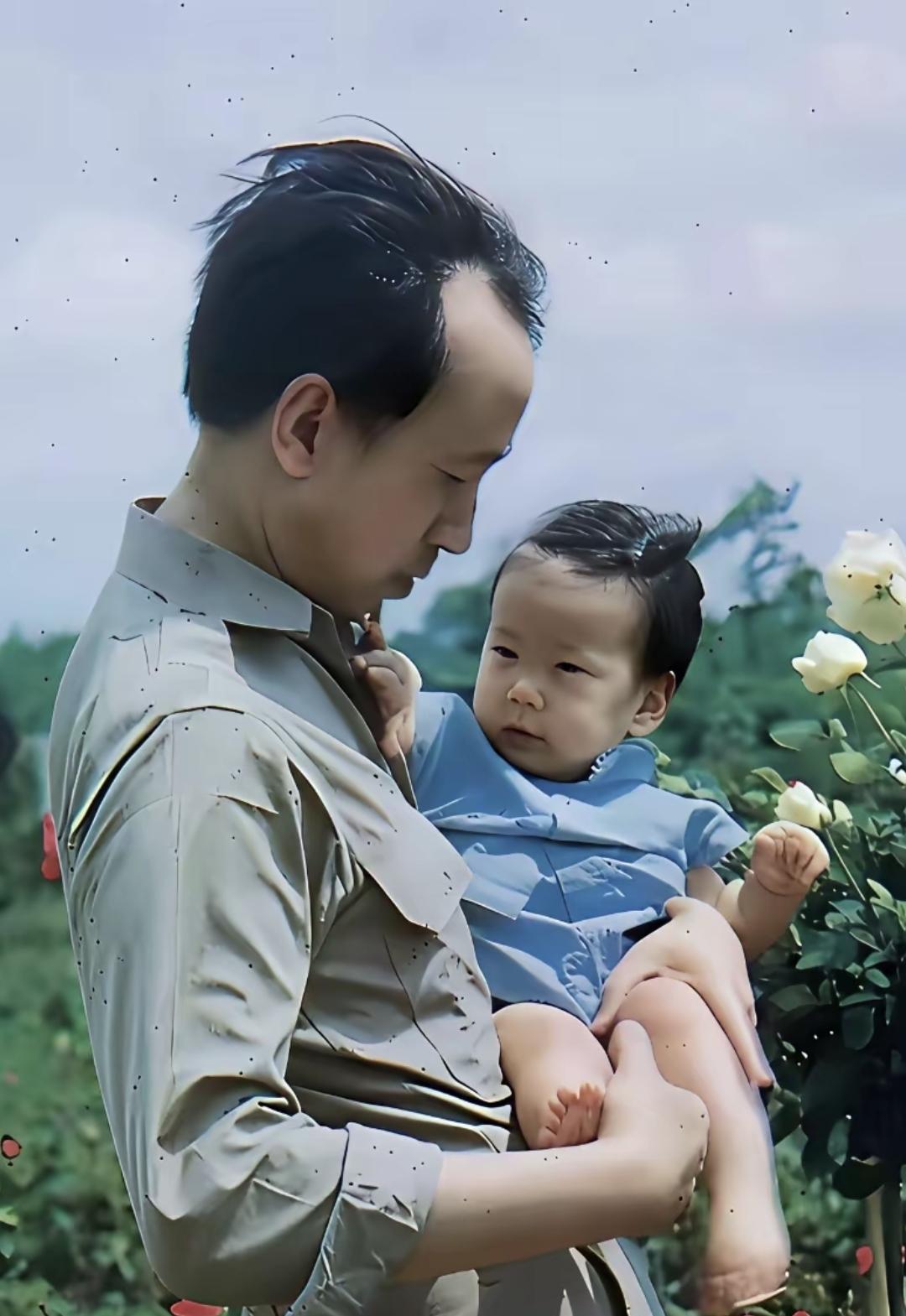 1950年美国，39岁的钱学森抱着刚满一周岁的小女儿钱永真，他低头温柔凝视襁褓中