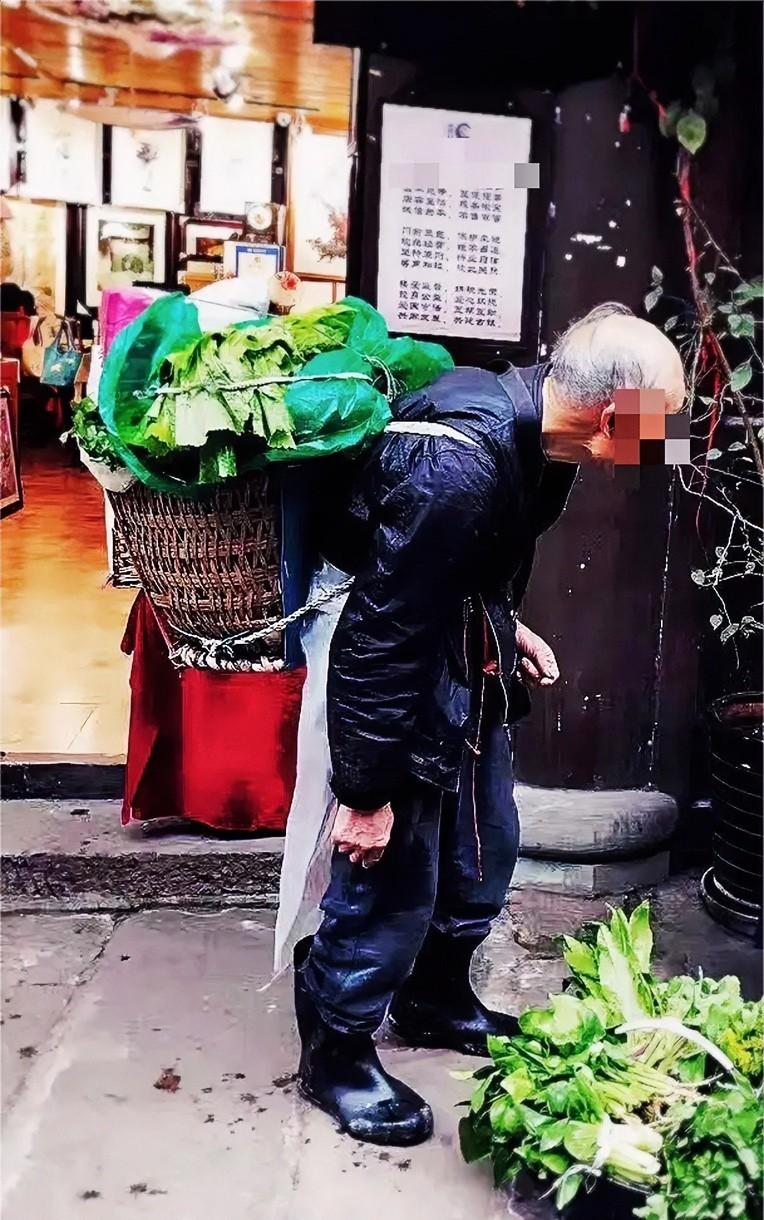 那天下着暴雨，

一个68岁的大爷背着一筐菜，

躲进路边的餐馆屋檐下。

他浑