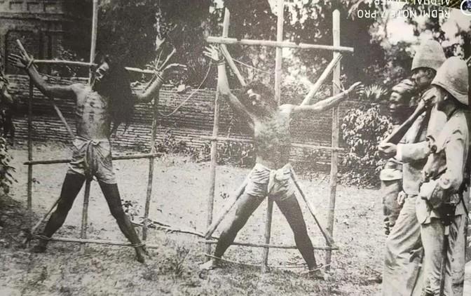 1889年，英国殖民者正在用“晒人干”的酷刑处死两个缅甸爱国者。他们四肢被绑在米