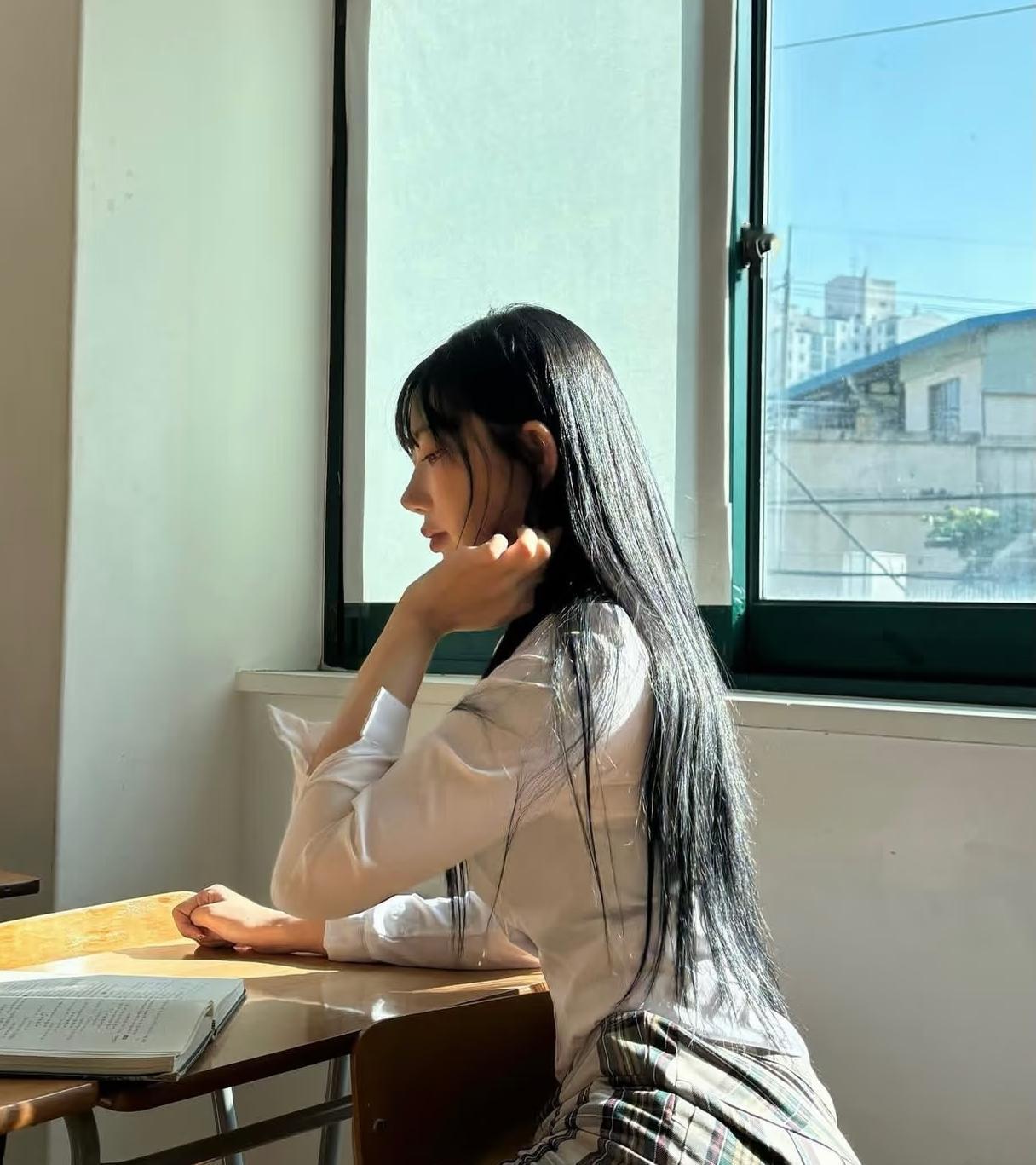 女孩坐在教室窗边，思考着什么。窗边女孩自拍