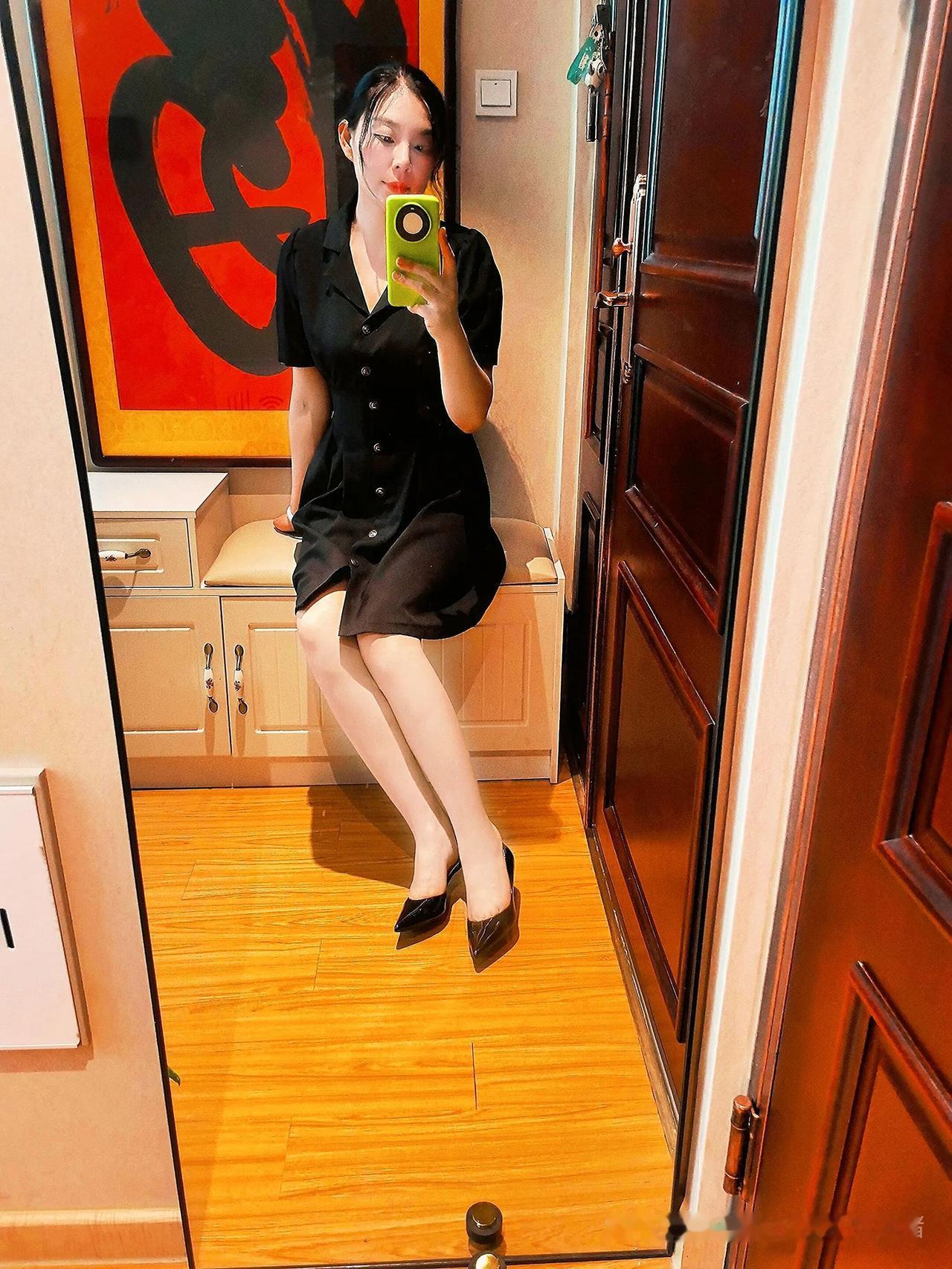 穿黑色连衣裙，拍自拍美照。