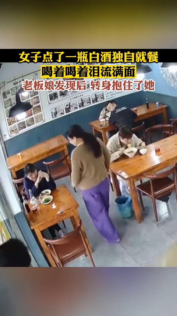 女子点了一瓶白酒独自就餐，喝着喝着泪流满面，老板娘发现后转身抱住了她。