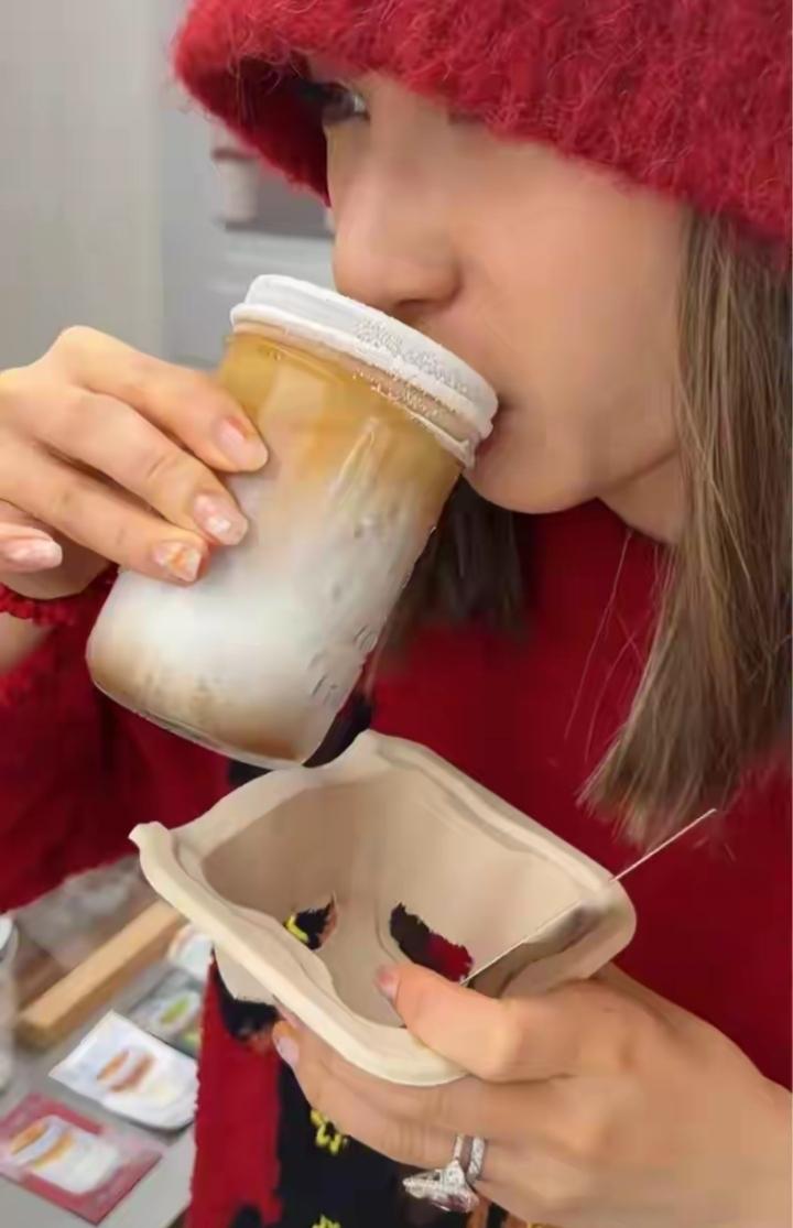 何超莲近期出镜状态绝了！一手一杯咖啡悠闲自在，身穿红色马上有钱毛衣，戴着红色帽子