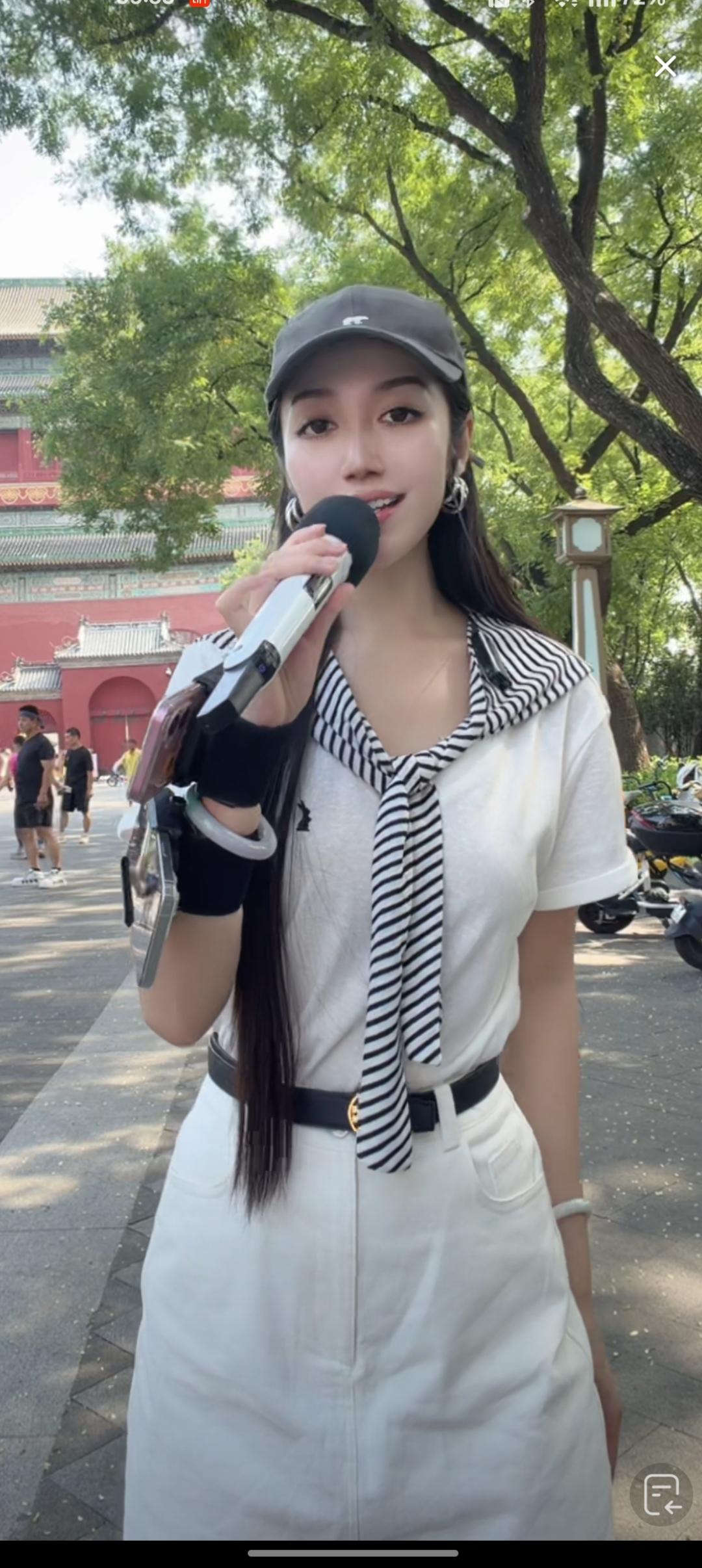 一个女孩在户外拿着麦克风唱歌。