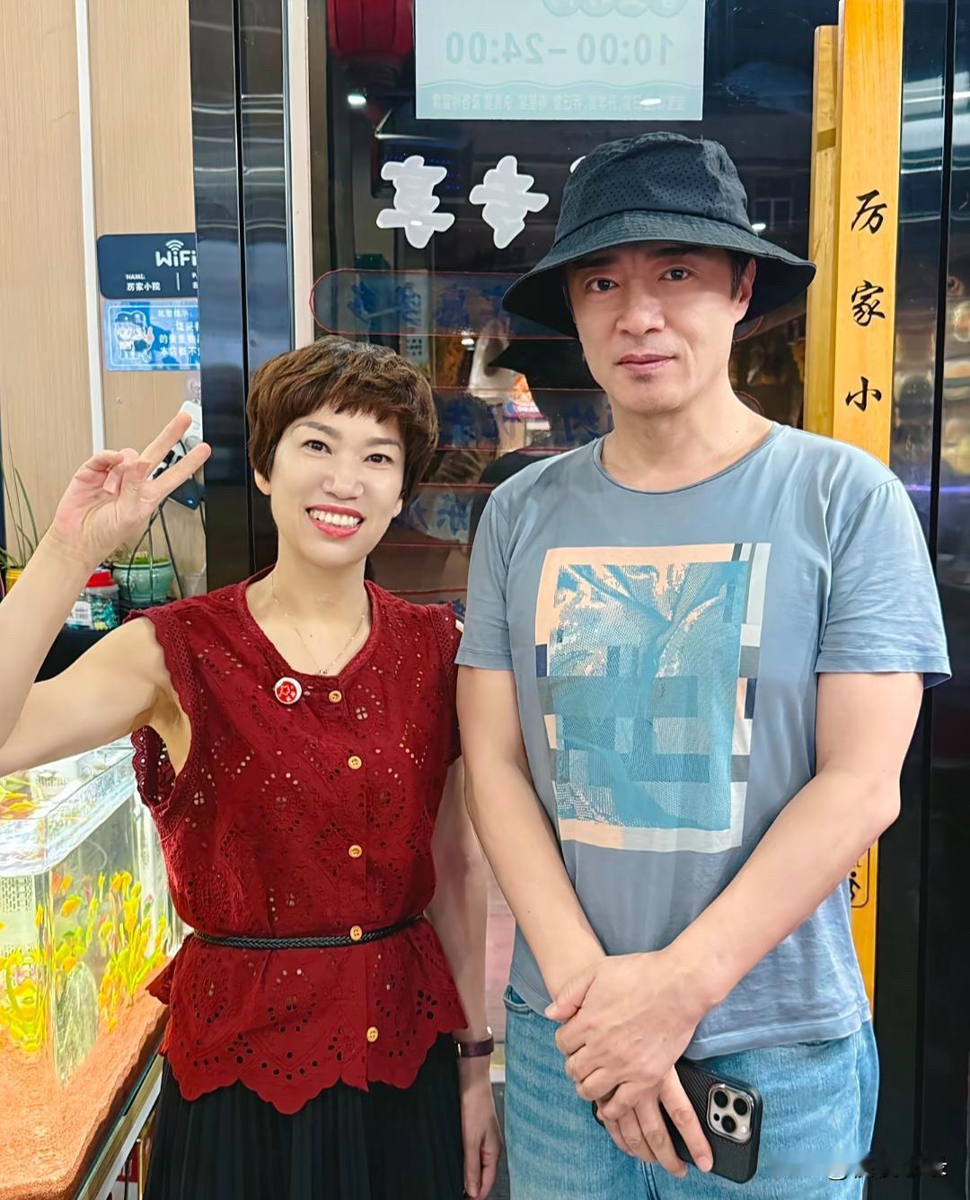 56岁何中华在浙江金华一家餐馆吃饭，和老板娘拍摄了合影。他真人高大帅气，身上完全