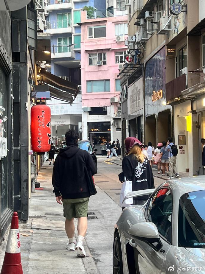 香港街头偶遇陈奕迅夫妇，50岁的陈奕迅看起来很年轻，穿搭外套+短裤，看着很随意 