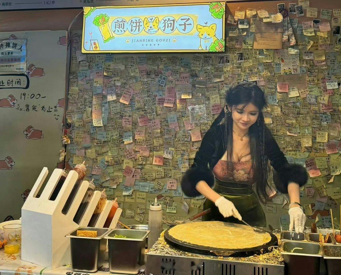 狗头萝莉卖煎饼时的照片，背景墙贴都是网友的鼓励。后来，她被人举报。原因是她穿衣服