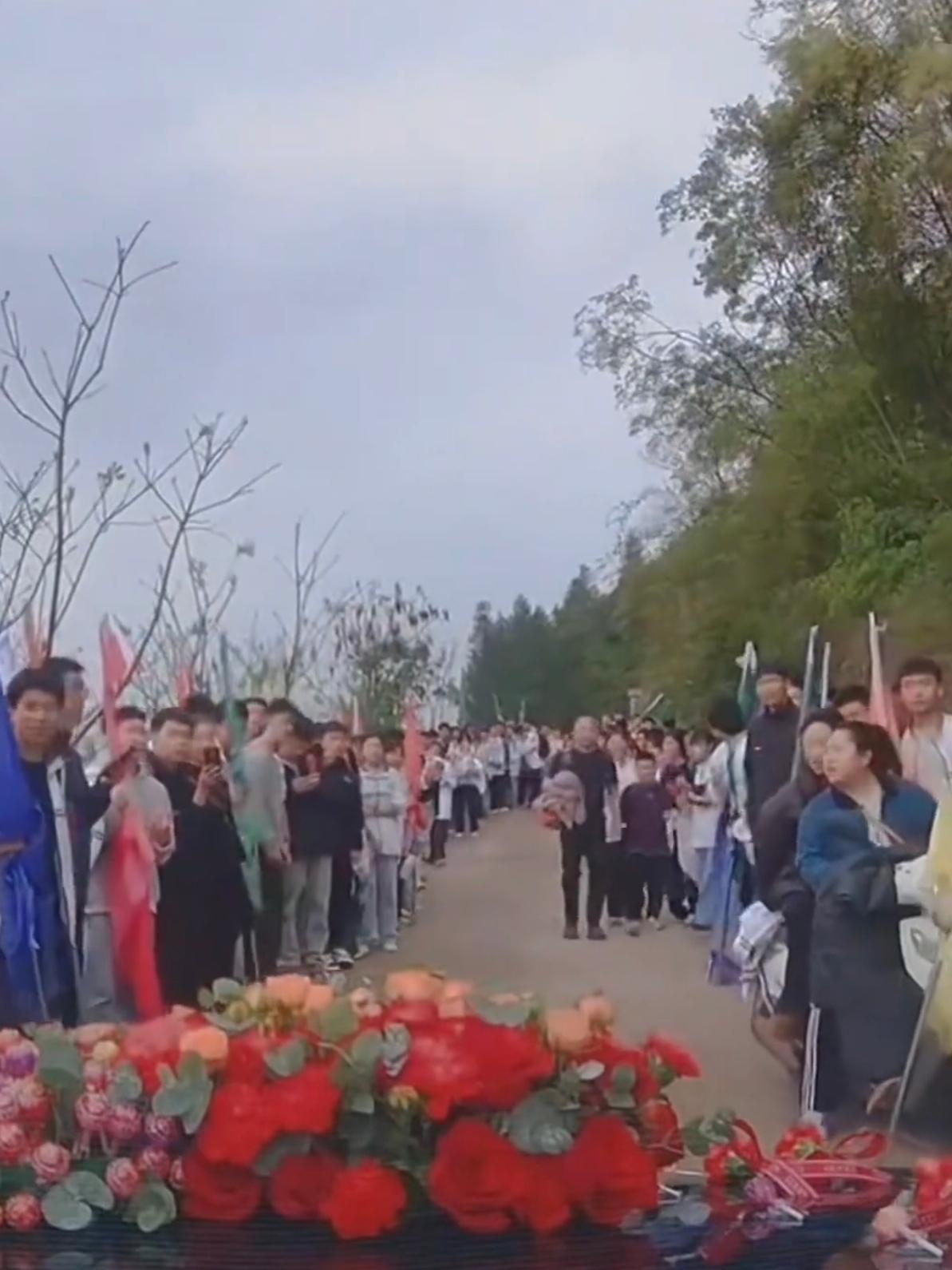 四川泸州，一支接亲车队在赶路途中，和一群正在春游的孩子们窄路相逢，孩子们没有哄乱