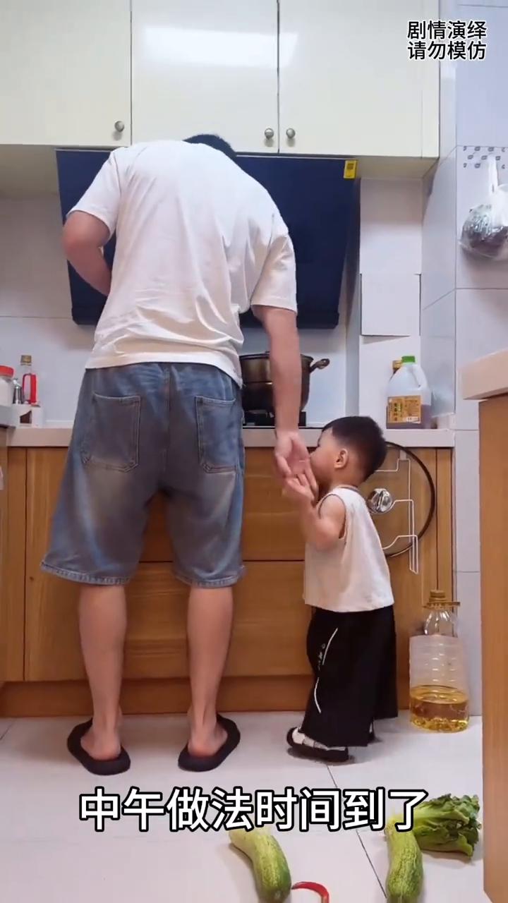 中午做法时间到了，只见爸爸在厨房忙得不可开交，谁知儿子跑过来捣乱他，这整的爸爸做