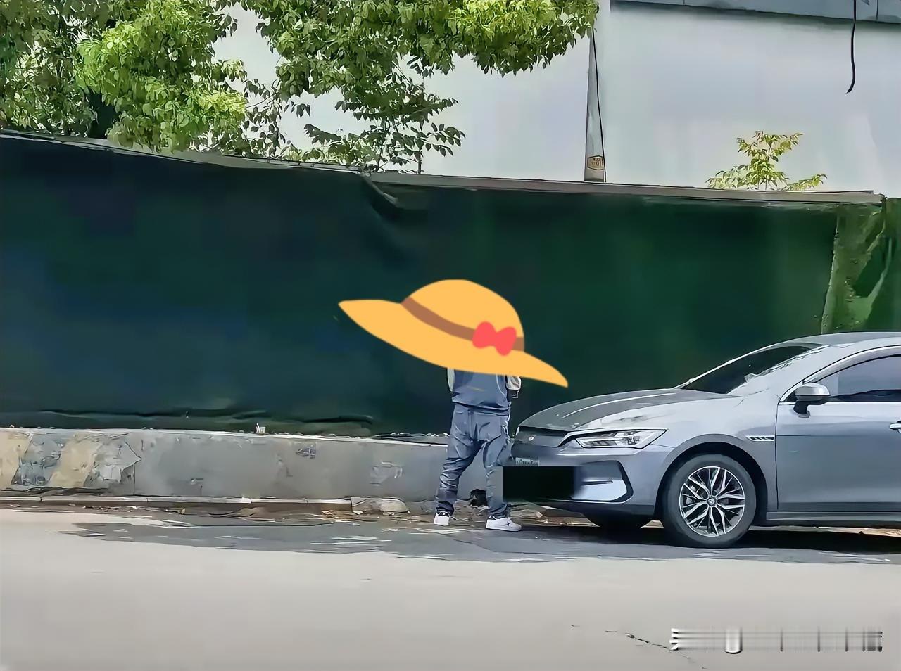 这男子在车头前干啥好事了，依着时尚干净，大白天车来车往，喝水太多了吧，应该是憋不