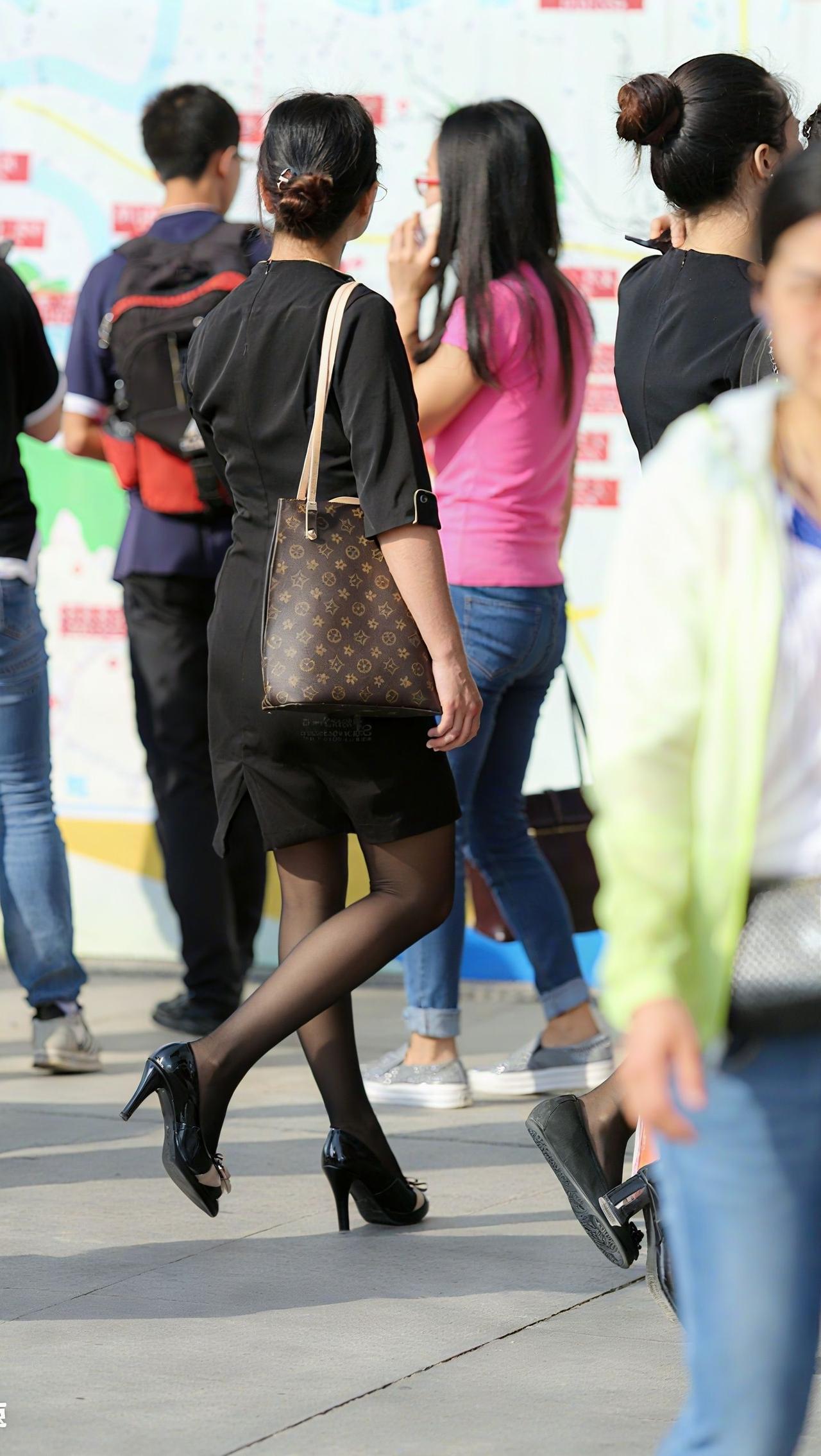 优雅的黑裙搭配高跟鞋，手提包点缀，都市女性的时尚日常。