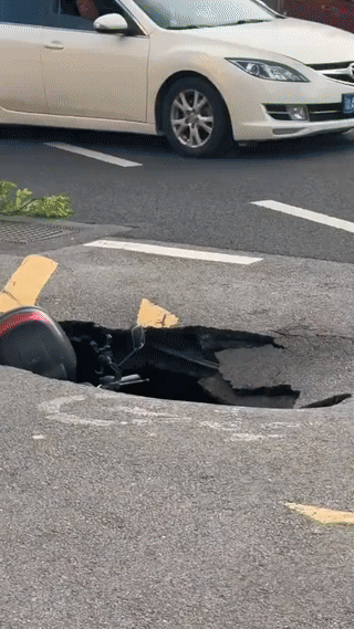 这位大哥真是吓坏了！
他刚才骑电动车正常在公路上行驶。
突然发生了路面塌陷事故！