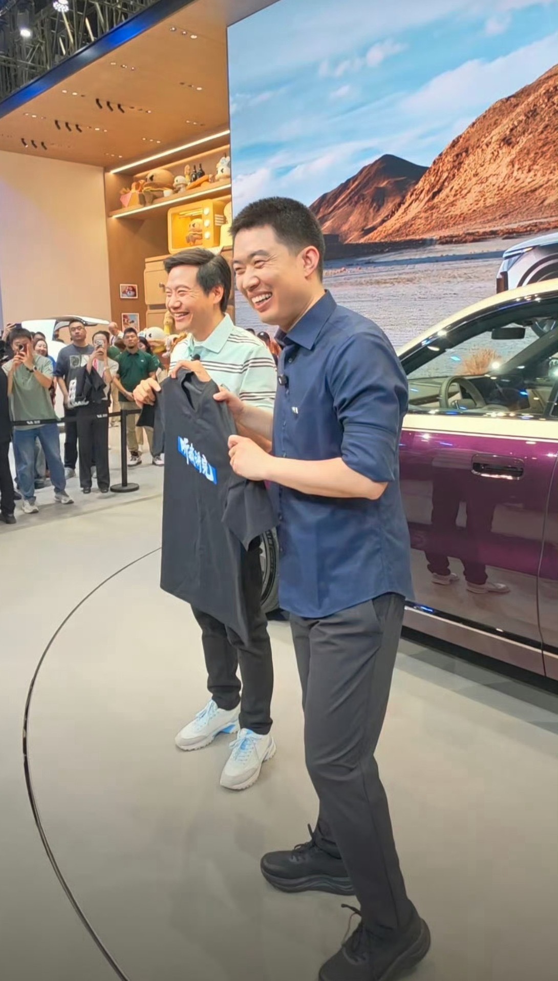 雷军送李想听我讲完T恤雷军玩梗有水平的，到理想展台给李想送了件印有“听我讲完”的