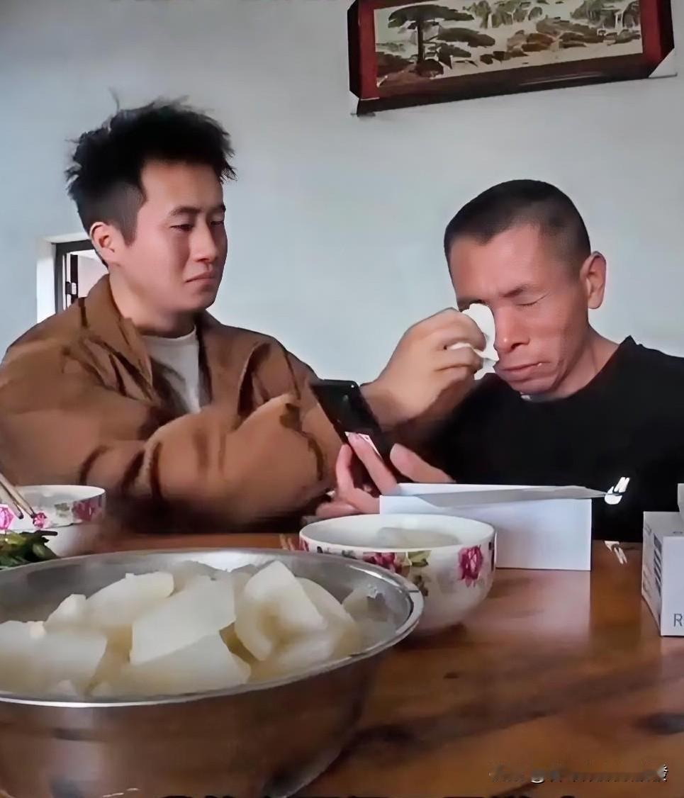 父子俩一起吃饭时，父亲细心地把满满一盆菜和另一盘菜，往儿子面前推了推，让菜离他更