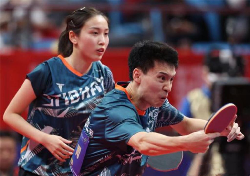 这张照片应该是两位乒坛球员比赛中一起合作的精彩瞬间吧！

我只认出了额头光洁饱满