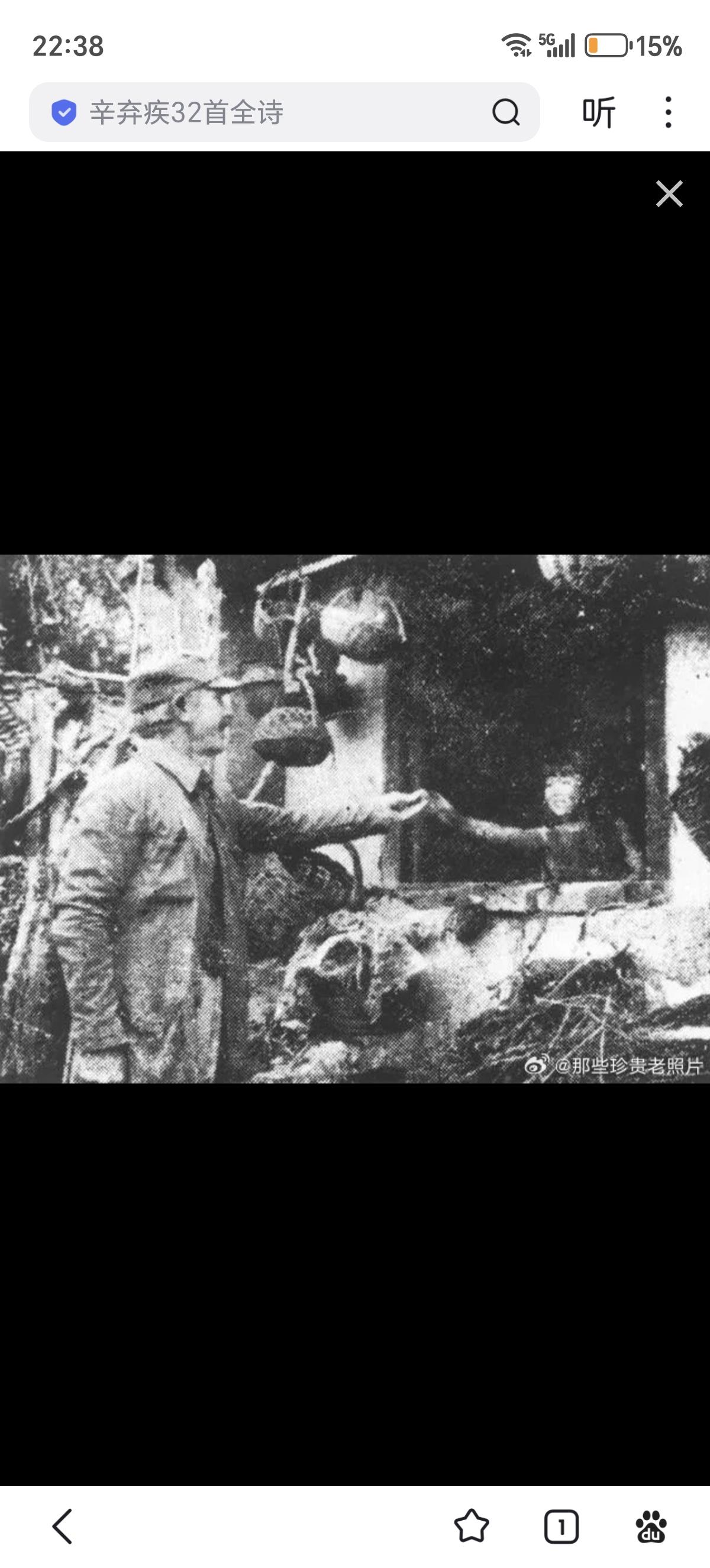 1938年，山西五台松岩口，白求恩大夫用樱桃逗村中女孩。