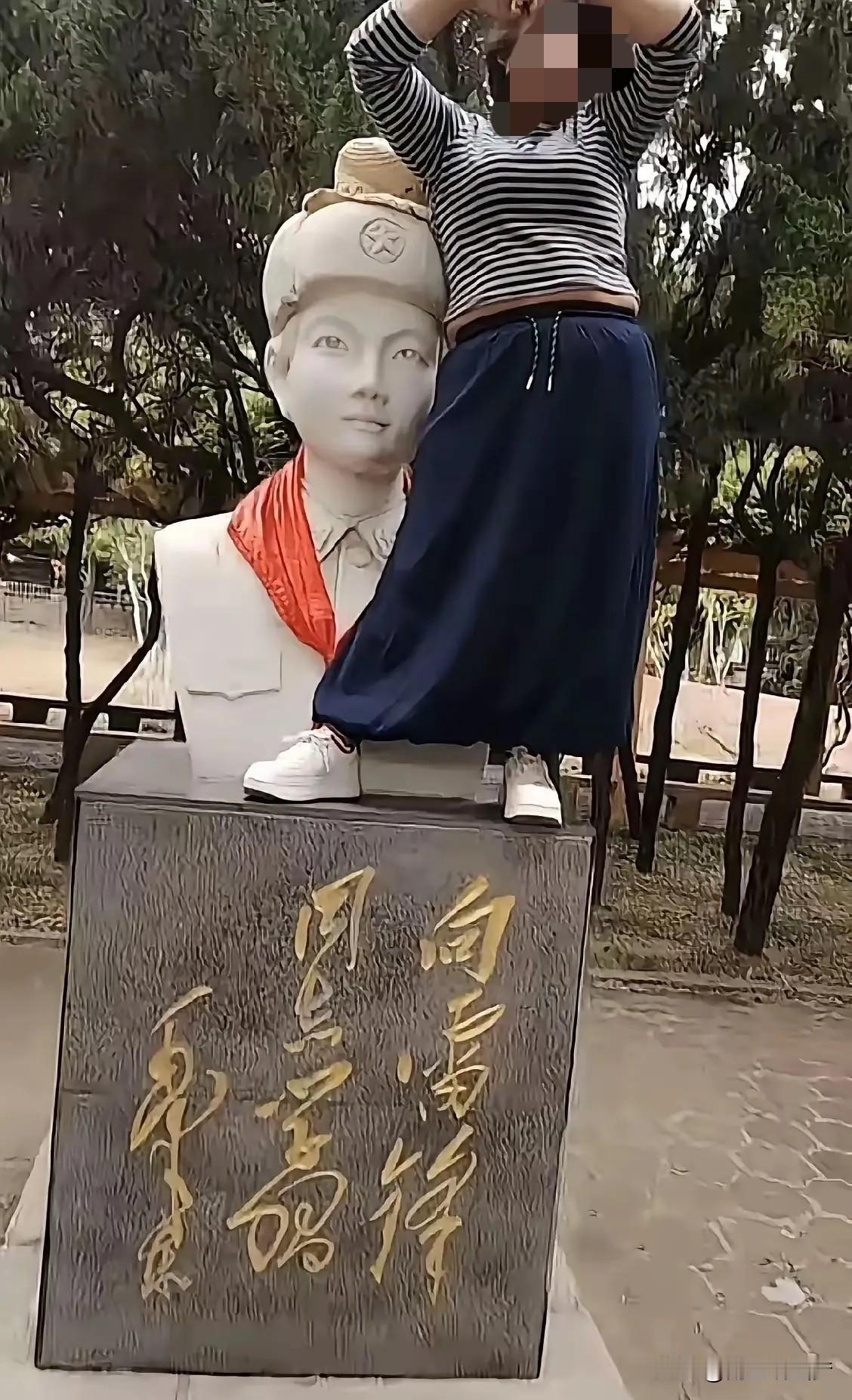 大家看看这张图，心里什么滋味？

一个姑娘，双脚踩在英雄长眠的石碑上，高高举起双