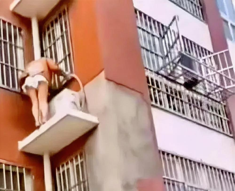 美女站在窗户外头干什么呢？应该不是修空调。